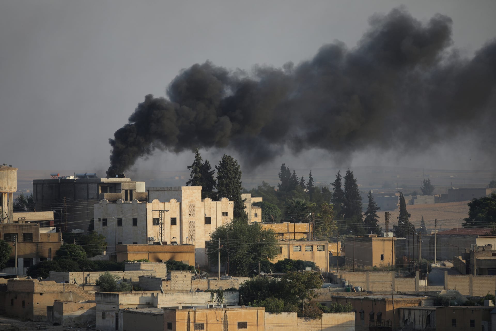 <p>Smoke rises above the Syrian border town of Tel Abyad, as seen from Turkey, on October 13, 2019.</p>
