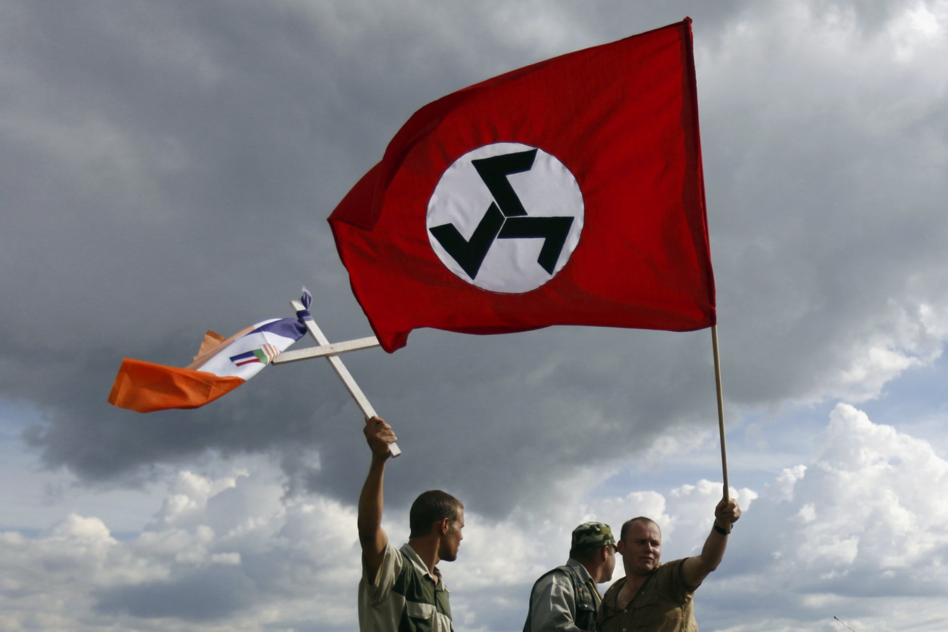 <p>Supporters of the Afrikaner Resistance Movement (AWB) leader Eugene Terre’Blanche wave the party’s flag (R) and an apartheid era flag during his funeral in Ventersdorp in South Africa’s North West Province, on April 9, 2010.</p>
