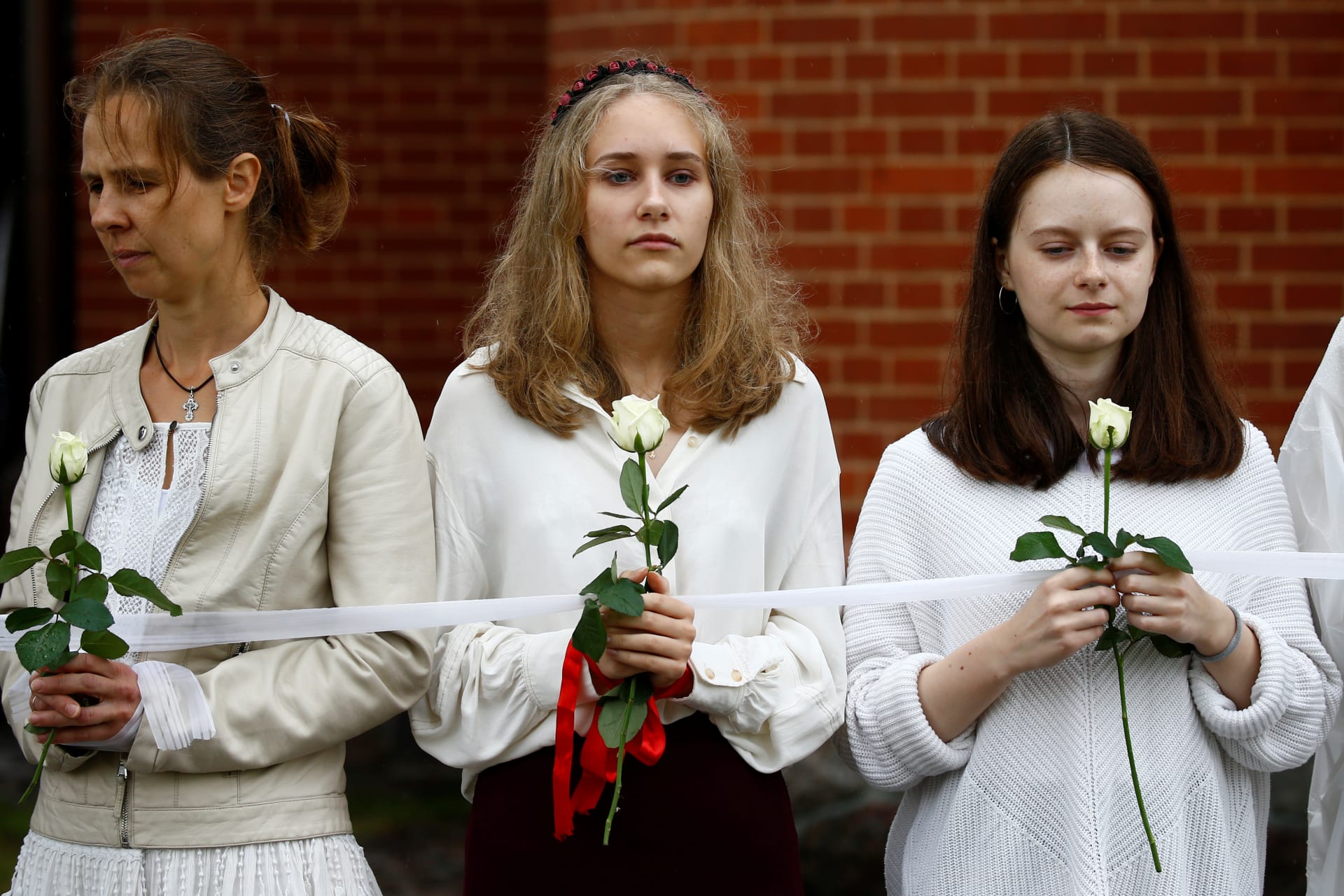 <p>Women hold flowers as they participate in a rally against presidential election results at the Independence Square in Minsk, Belarus. August 27, 2020.</p>
