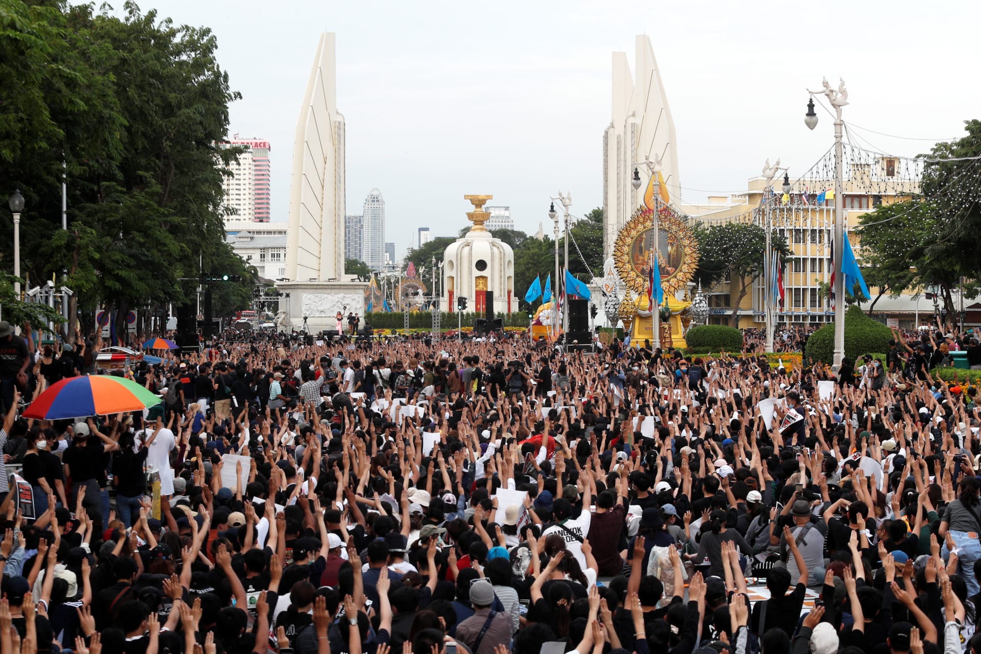 <p>Pro-democracy protesters raise their hands in a three-fingered salute during a rally near the Democracy Monument in Bangkok, Thailand on August 16, 2020.</p>
