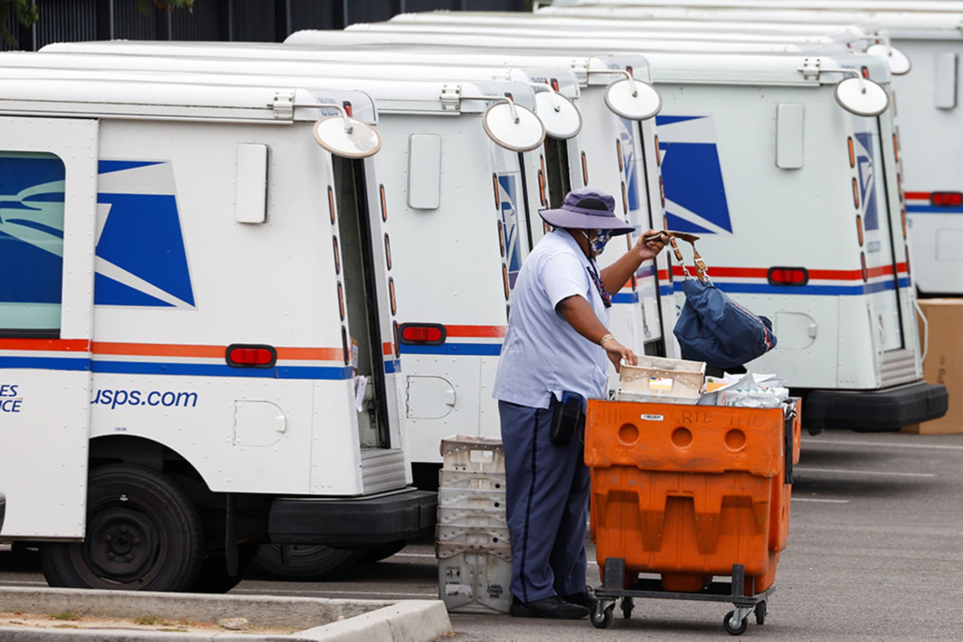 <p>A U.S. postal worker loads his truck as he begins his day during the outbreak of COVID-19 in Carlsbad, California.</p>
