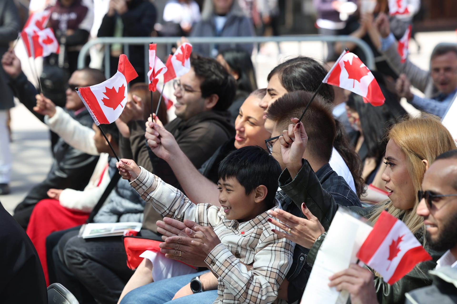 <p>New Canadians wave the national flag during a citizenship ceremony in Toronto.</p>
