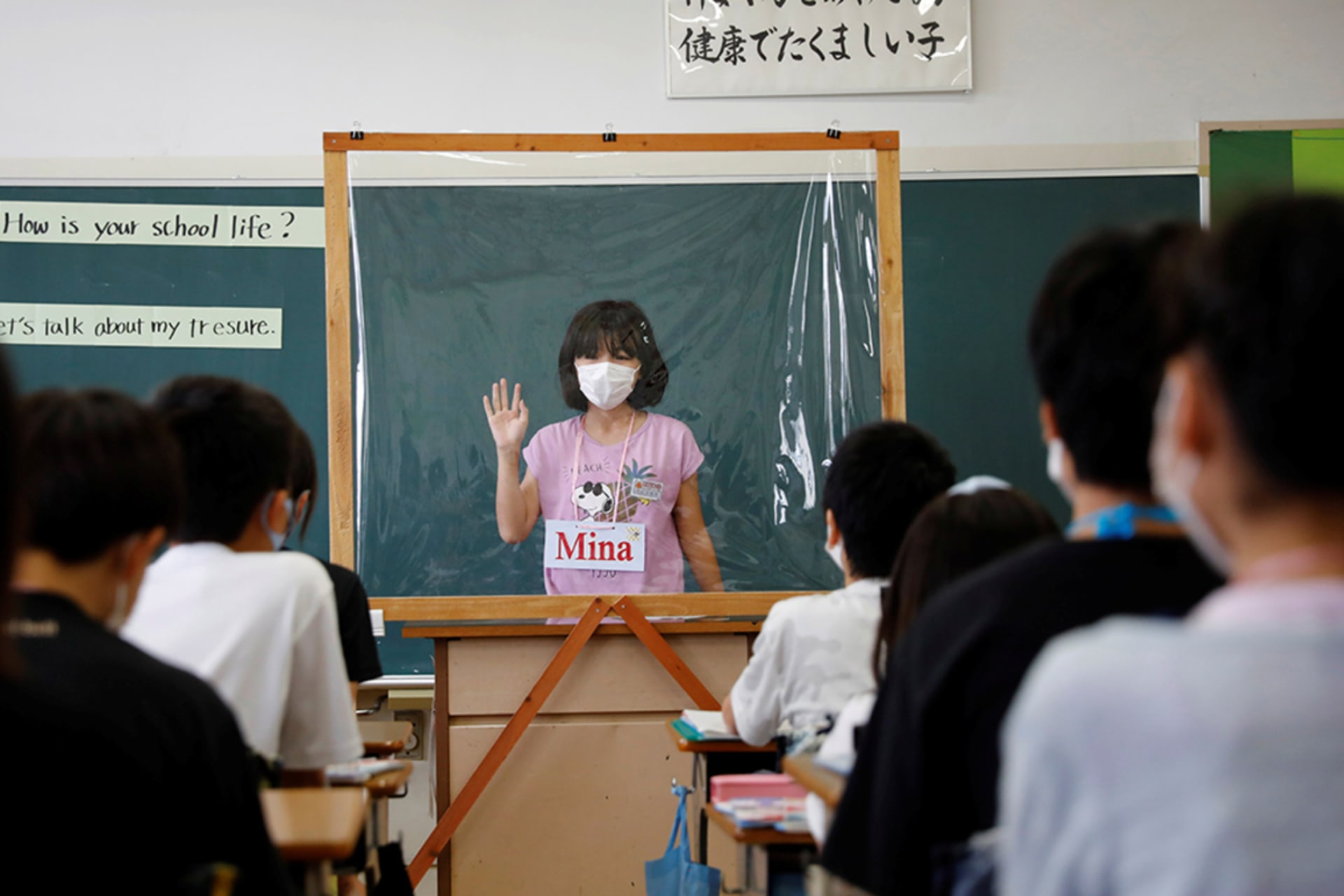 <p>A student gives an English presentation behind a plastic sheet at a Funabashi elementary school.</p>
