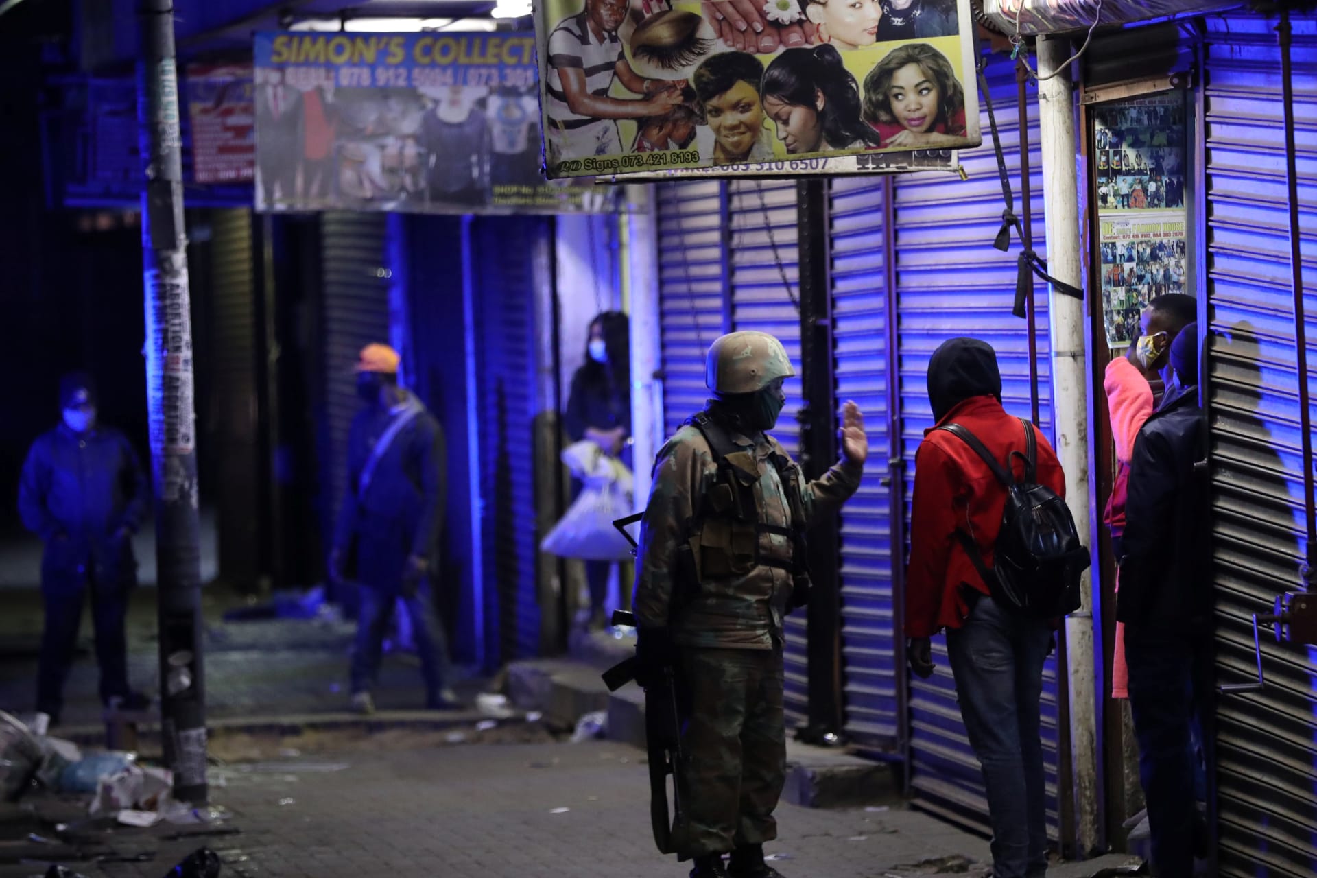 <p>A member of the South African military talks to a man during a patrol as a nighttime curfew is reimposed amid a nationwide coronavirus disease lockdown, in Johannesburg, South Africa, on July 13, 2020. </p>
