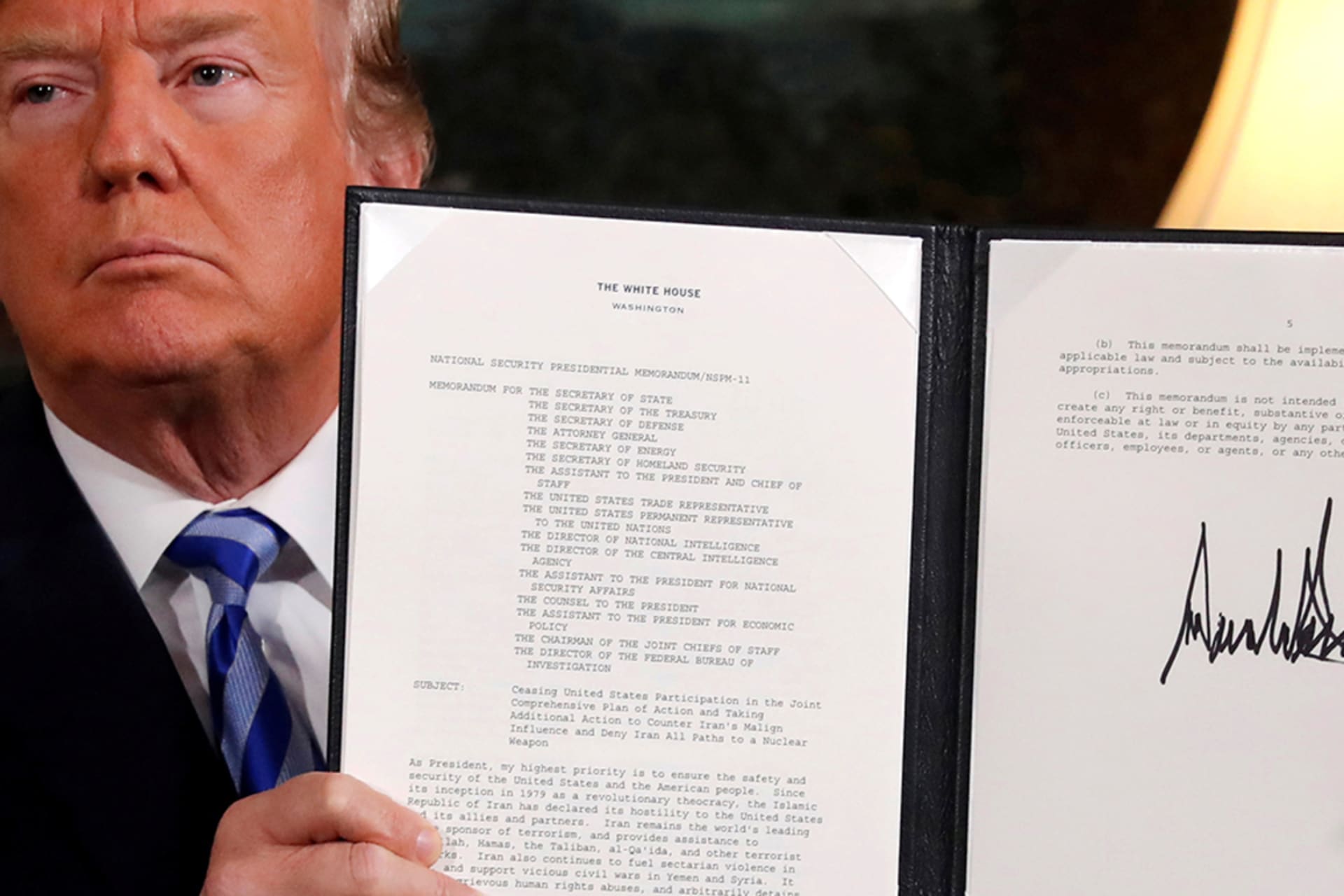 <p>President Trump holds up a proclamation declaring his intention to withdraw from the Iran nuclear deal.</p>
