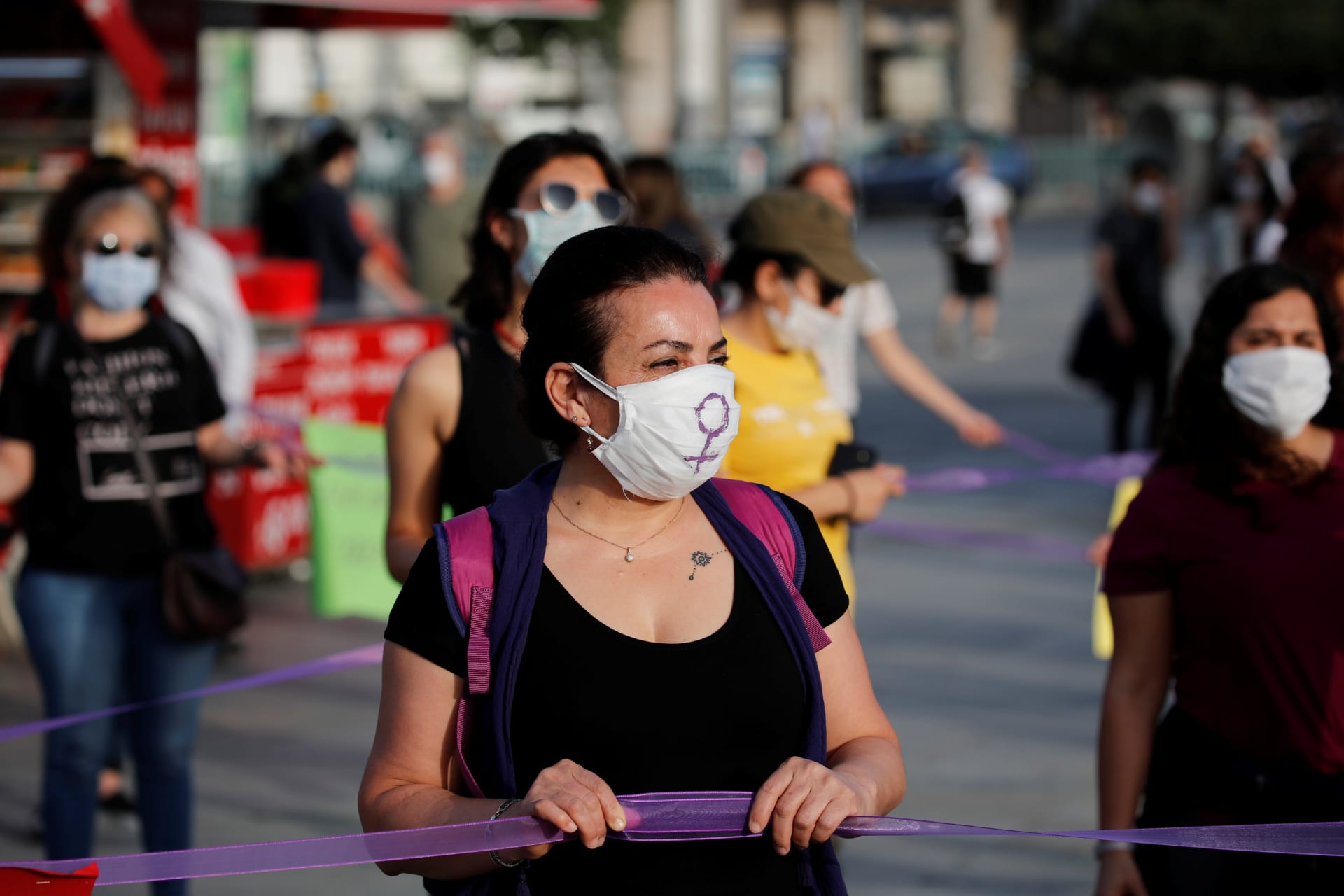 <p>Women keep social distance by holding onto purple ribbons as they protest against domestic violence, amid the spread of COVID-19, in Istanbul, Turkey, May 20, 2020.</p>
