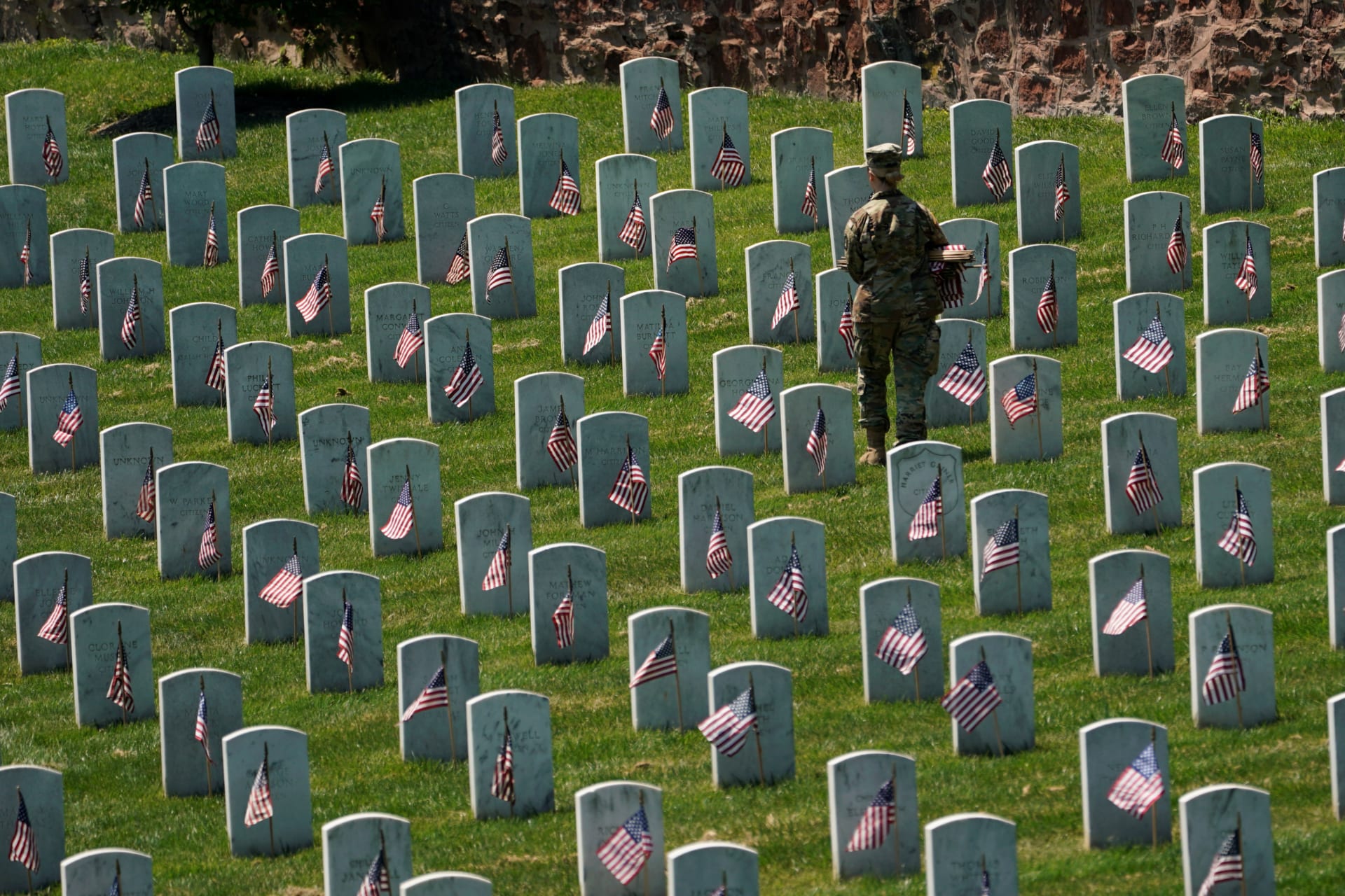 <p>An Old Guard places flags in front of headstones at Arlington National Cemetery on May 23, 2019. Kevin Lama/REUTERS</p>
