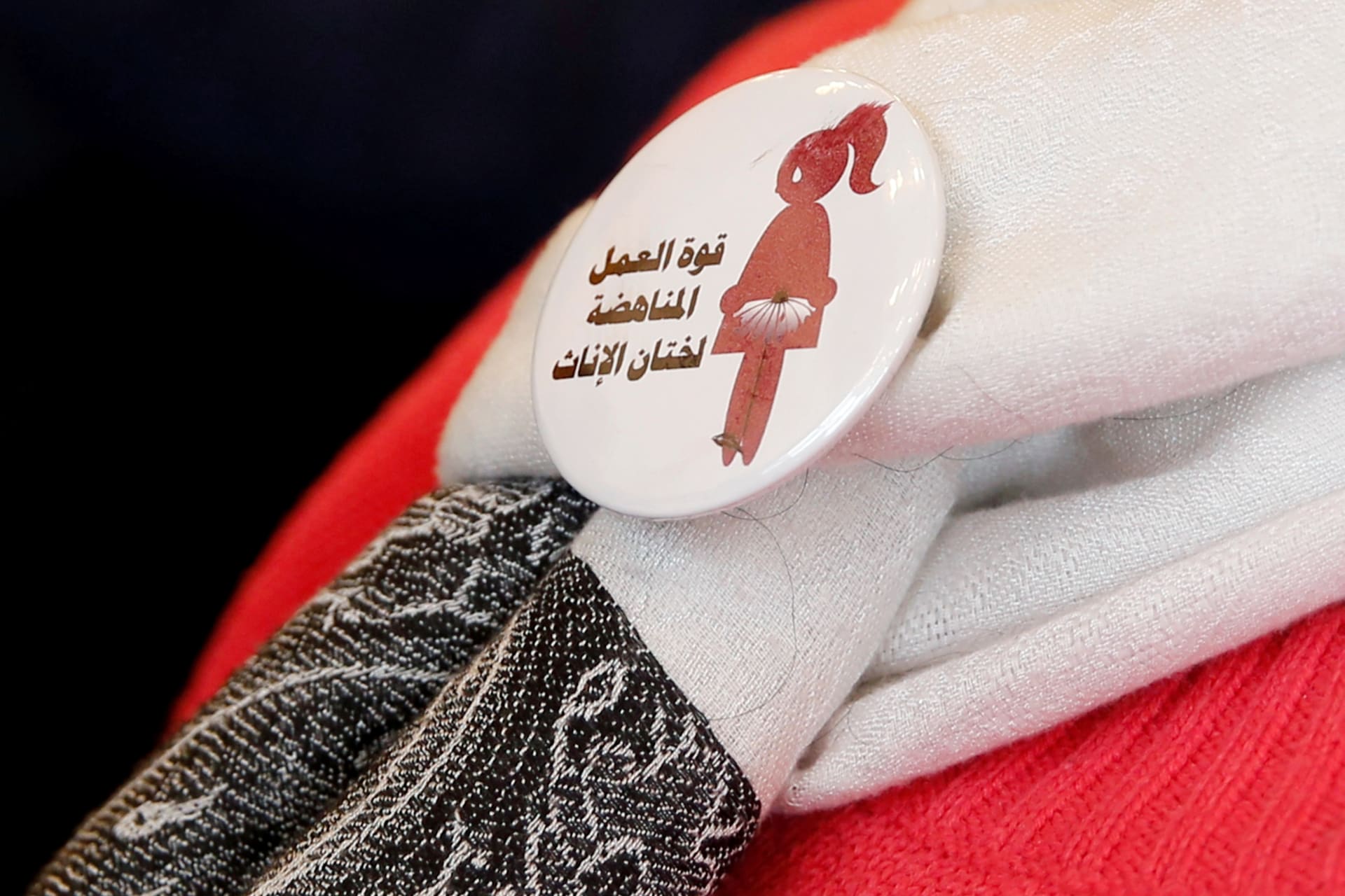 <p>A volunteer at a conference on International Day of Zero Tolerance for Female Genital Mutilation (FGM) in Cairo, Egypt, wears a badge that reads “The power of labor against FGM.” February 6, 2018.</p>
