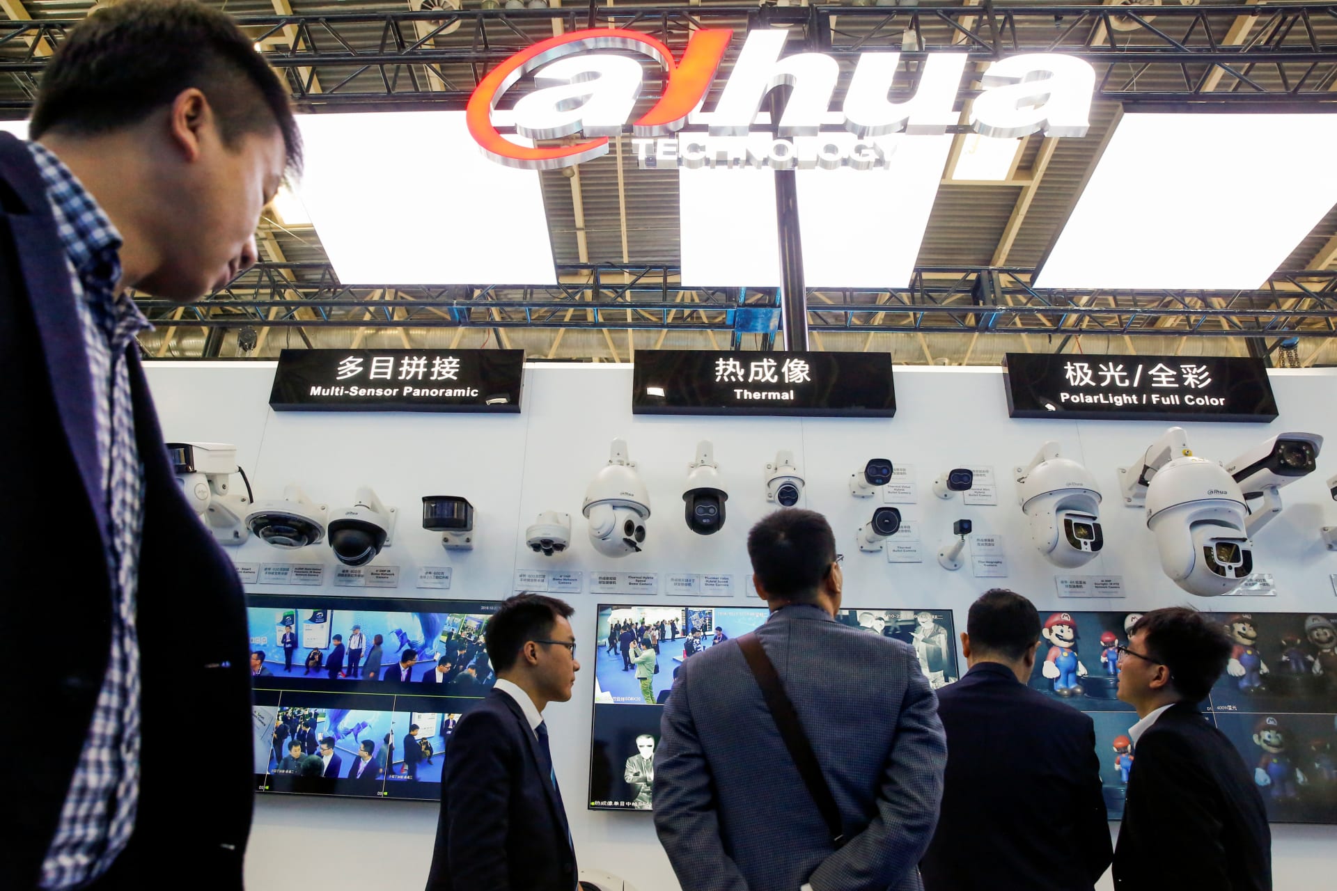 <p>Visitors look at CCTV cameras at the stall of the video surveillance product maker Dahua Technology.</p>
