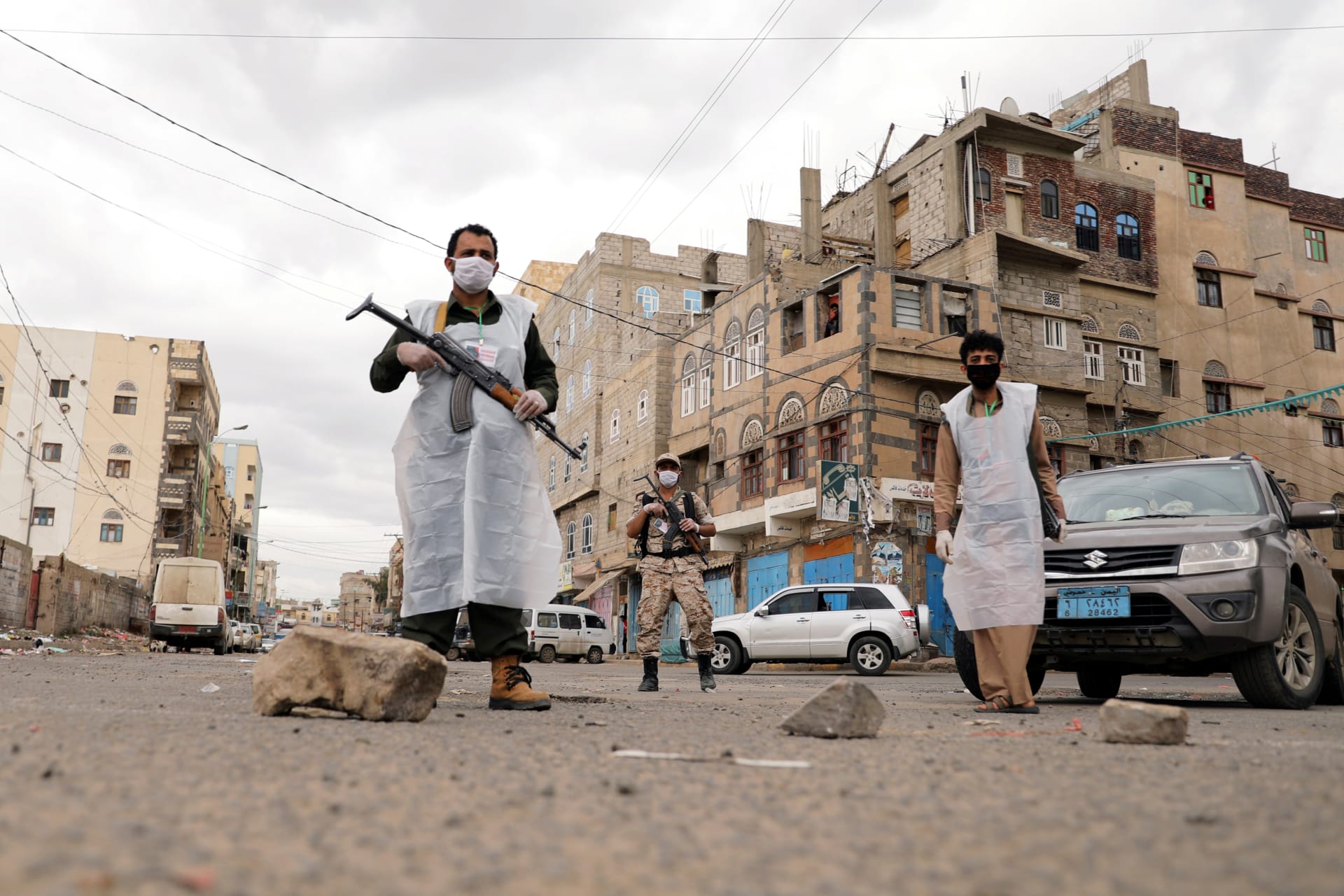 <p>Security men wearing protective masks stand on a street during a twenty-four hour curfew that was instituted over concerns about the spread of the novel coronavirus in Sanaa, Yemen, on May 6, 2020.</p>
