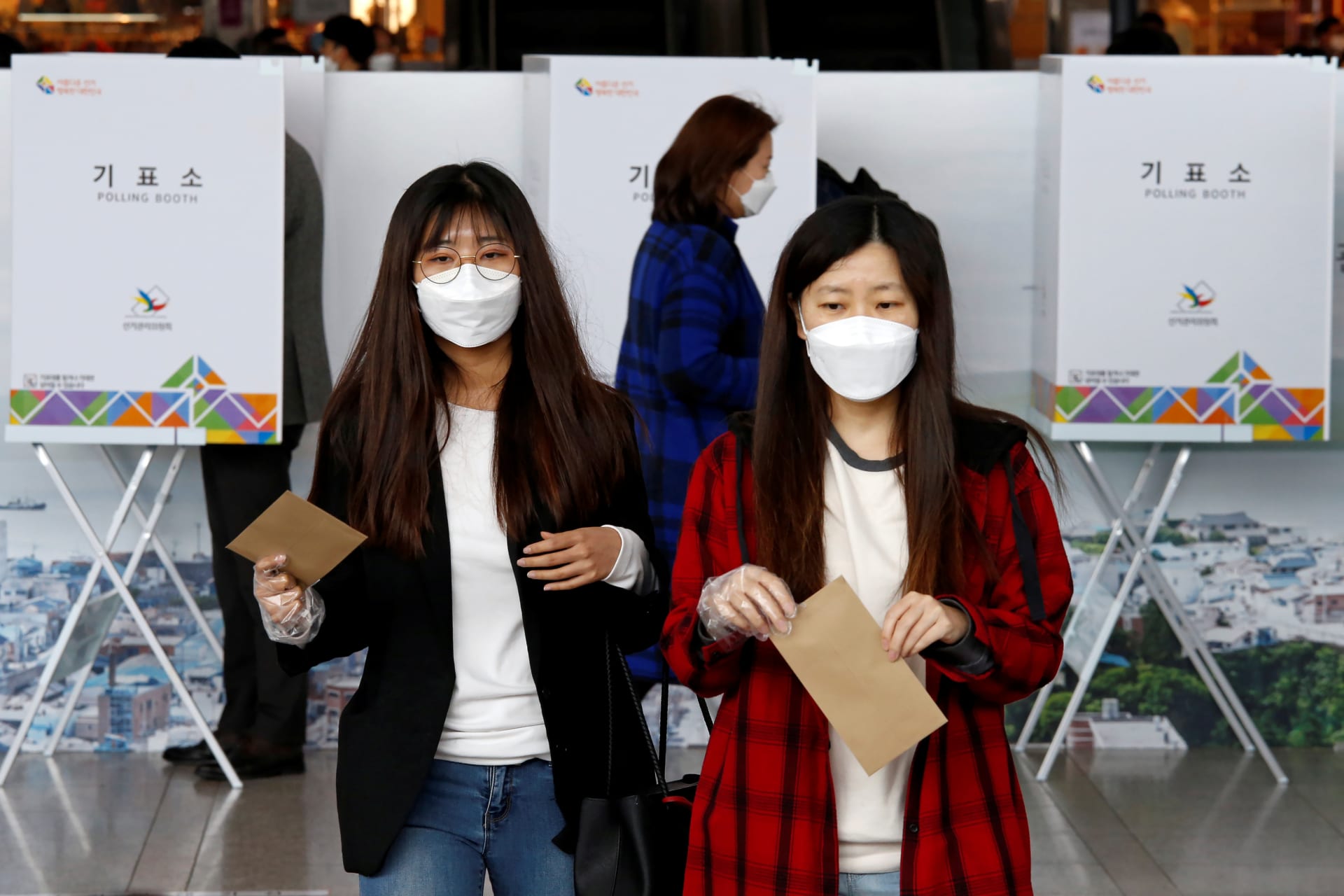 <p>Women wearing masks to prevent contracting COVID-19 cast their ballots for the parliamentary election at a polling station in Seoul, South Korea.</p>
