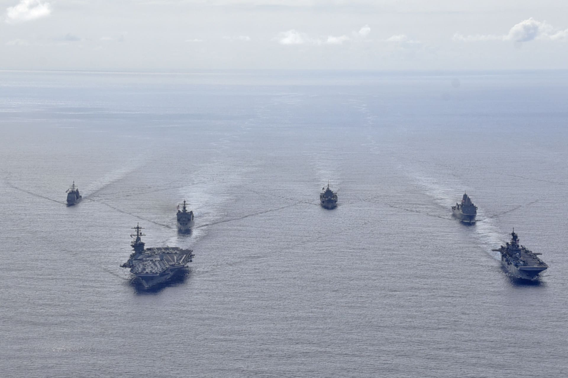 <p>U.S. Navy ships from the Theodore Roosevelt Carrier Strike Group, the America Expeditionary Strike Group, and the U.S. 7th Fleet command ship, USS Blue Ridge, transit the Philippine Sea in formation during a photo exercise on March 24, 2020.</p>
