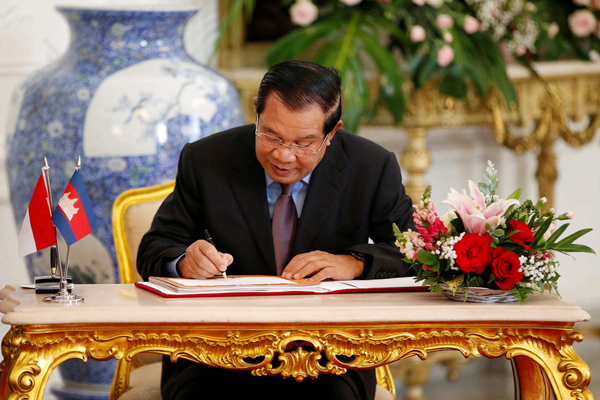 <p>Cambodian Prime Minister Hun Sen signs a guest book during his meeting with Indonesian President Joko Widodo.</p>
