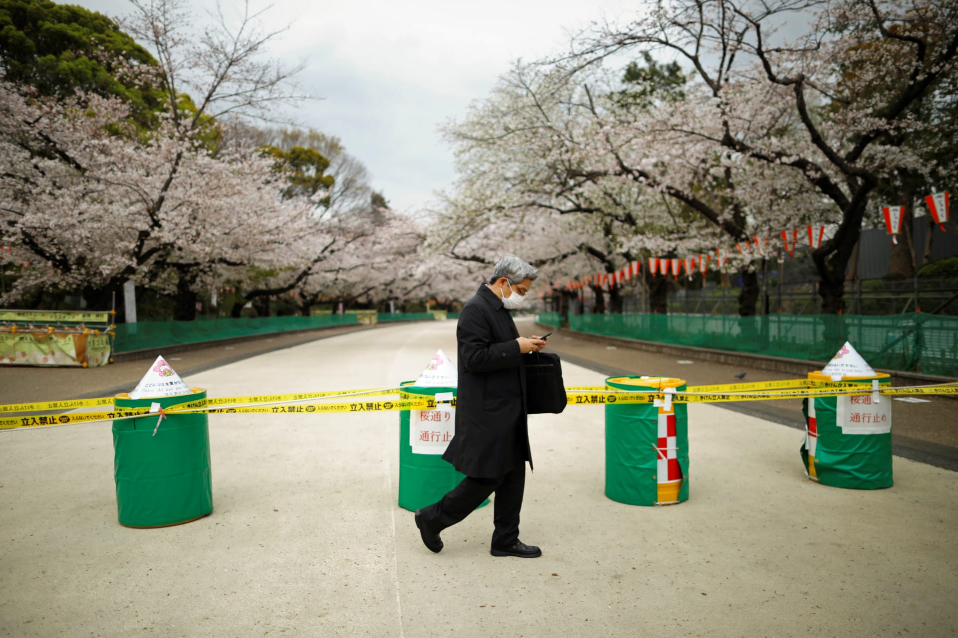 <p>A man wearing a face mask, following an outbreak of COVID-19, walks past a closed cherry blossom viewing spot during the first weekend after Tokyo Governor Yuriko Koike (not pictured) urged Tokyo residents to stay indoors.</p>
