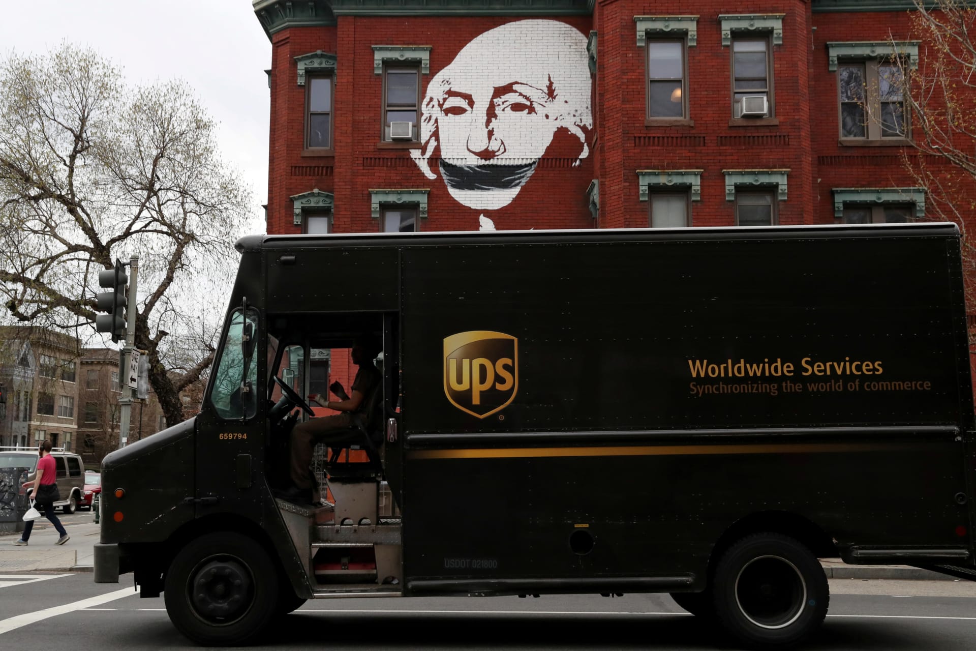 <p>A local mural takes on new meaning while a United Parcel Service (UPS) delivery truck pauses at a traffic light, as the spread of coronavirus disease (COVID-19) continues in Washington, U.S., March 27, 2020.</p>
