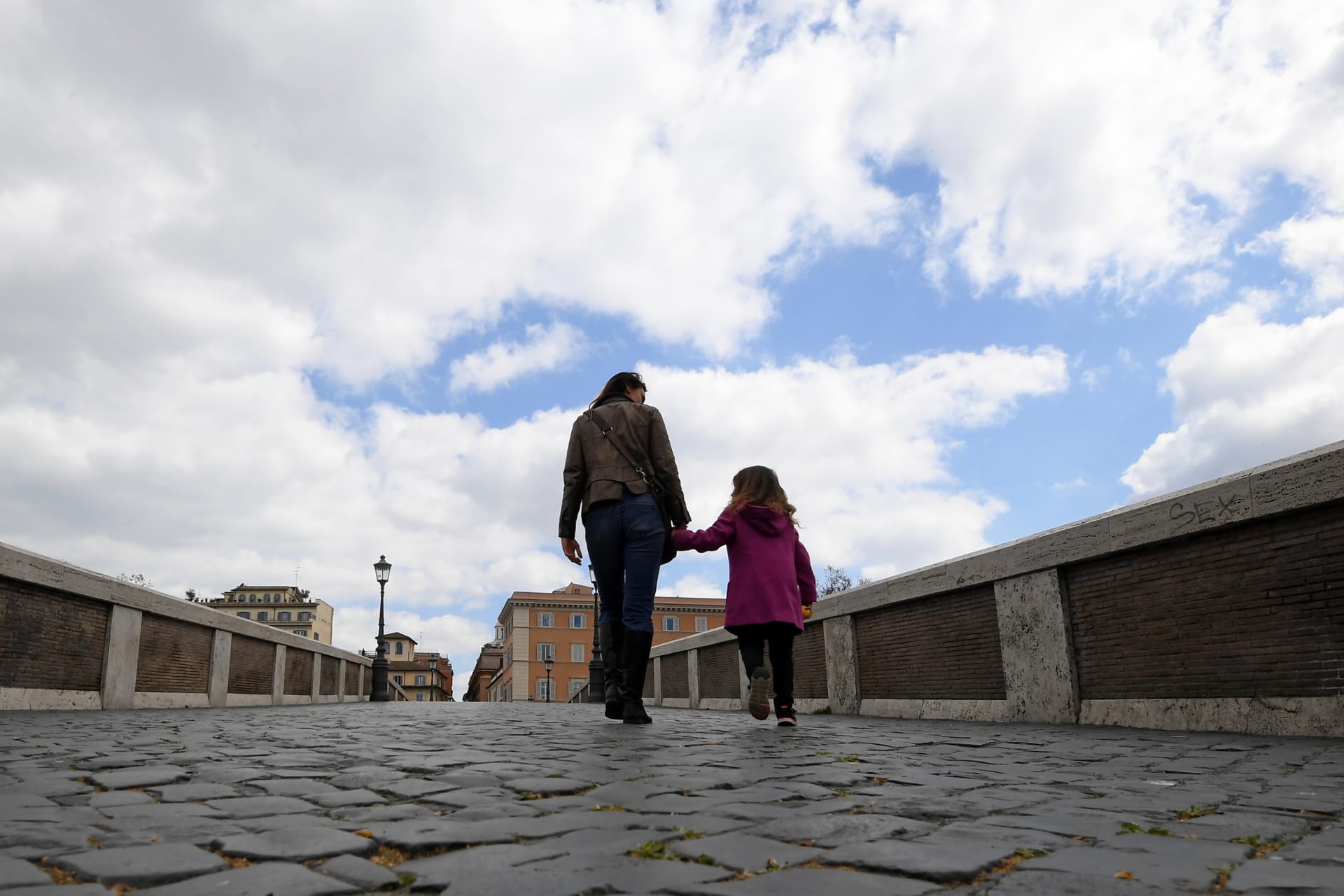 <p>A woman walks on the Ponte Sisto with her daughter in the Trastevere district as the spread of coronavirus disease (COVID-19) continues, in Rome, Italy, April 2, 2020.</p>

