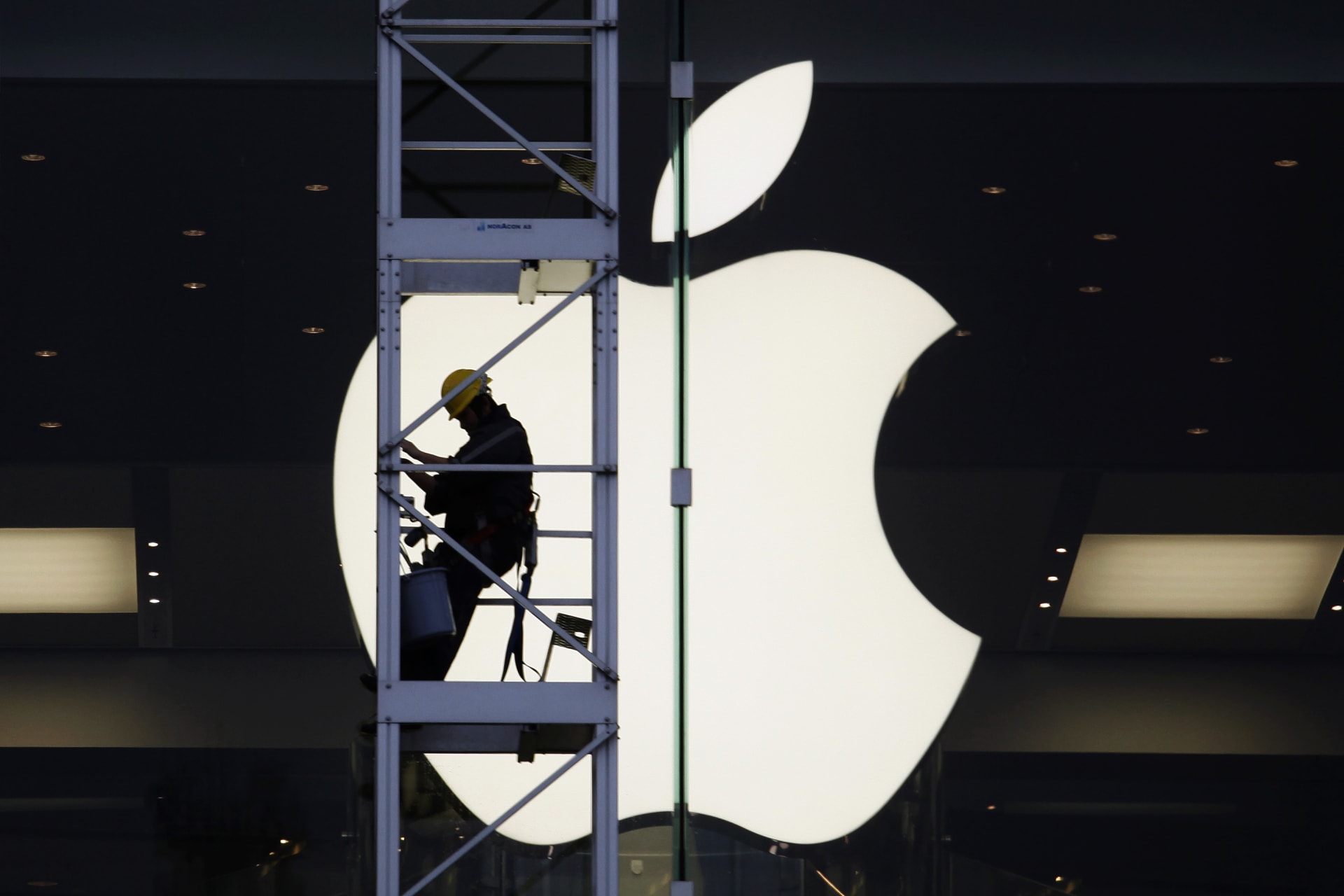 <p>A worker climbs outside an Apple store in Hong Kong.</p>
