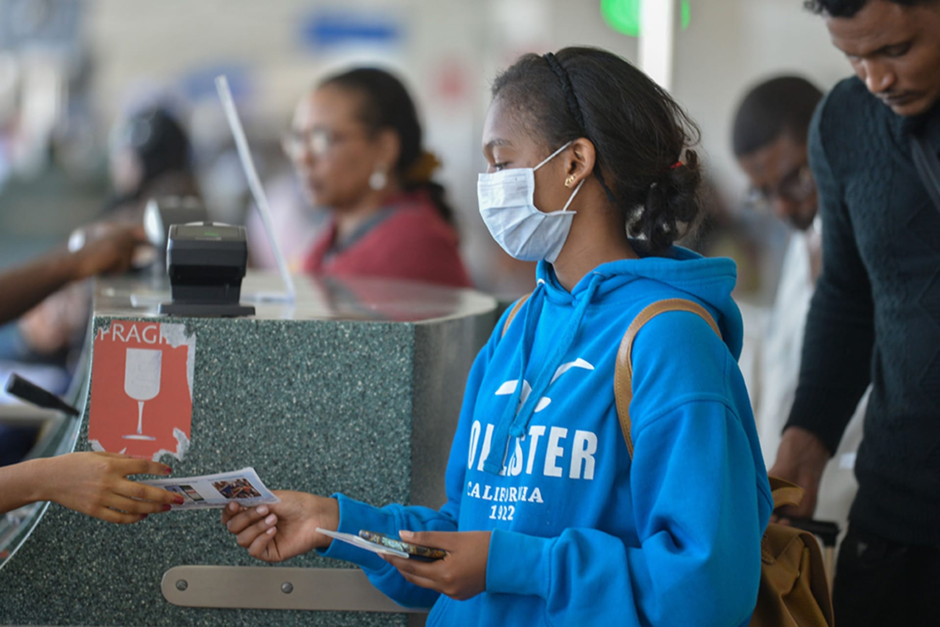 <p>A passenger wears a mask as she waits at passport control in Bole International Airport in Addis Ababa, on January 30, 2020, following an outbreak of coronavirus in China.</p>
