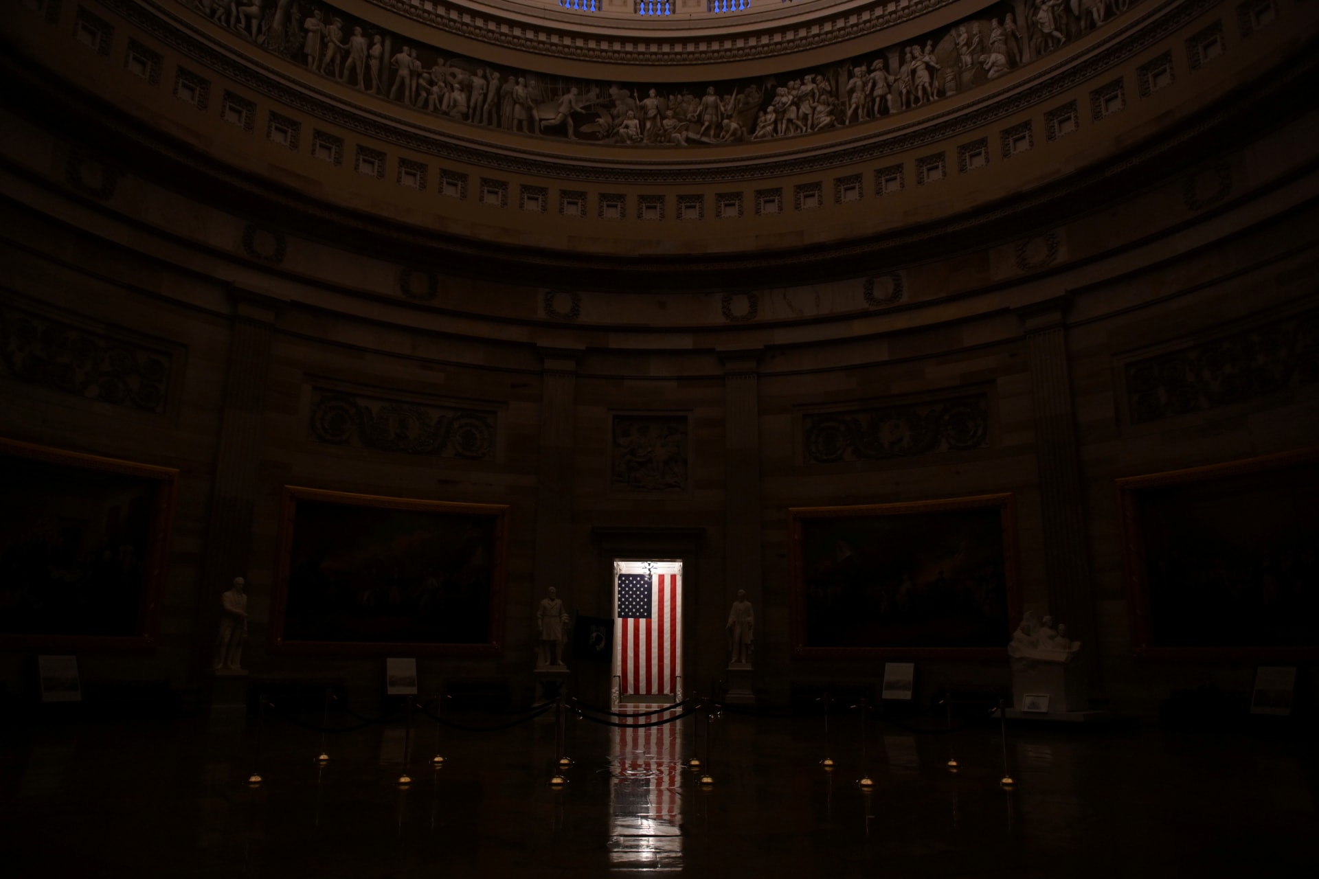 <p>An American flag is illuminated in the empty U.S. Capitol rotunda in Washington, U.S. on January 24, 2020. </p>

