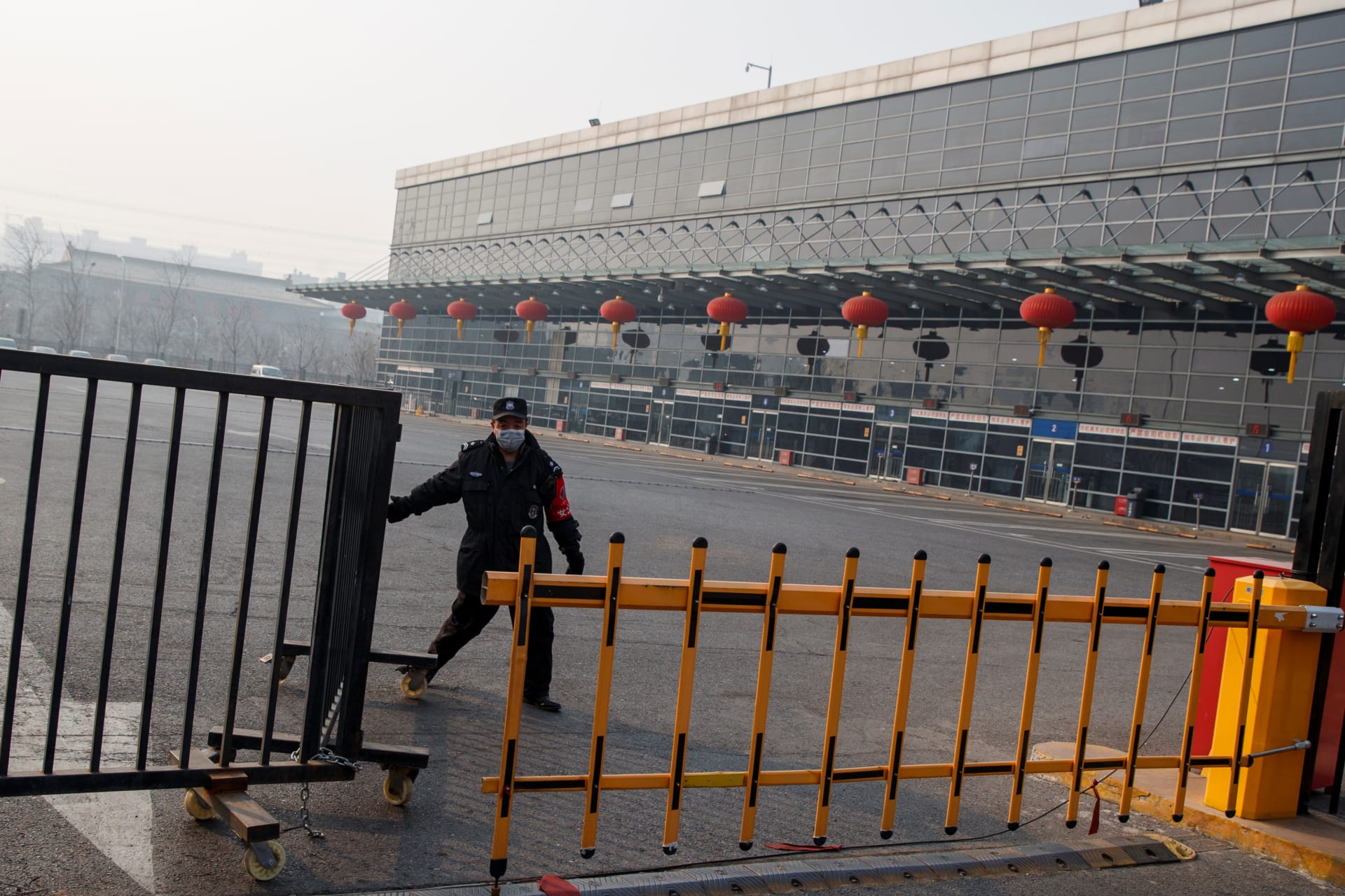 <p>A security guard closes a gate at the Sihui Long Distance Bus Station in Beijing after the city has stoped inter-province buses services as the country is hit by an outbreak of the new coronavirus, January 26, 2020.</p>
