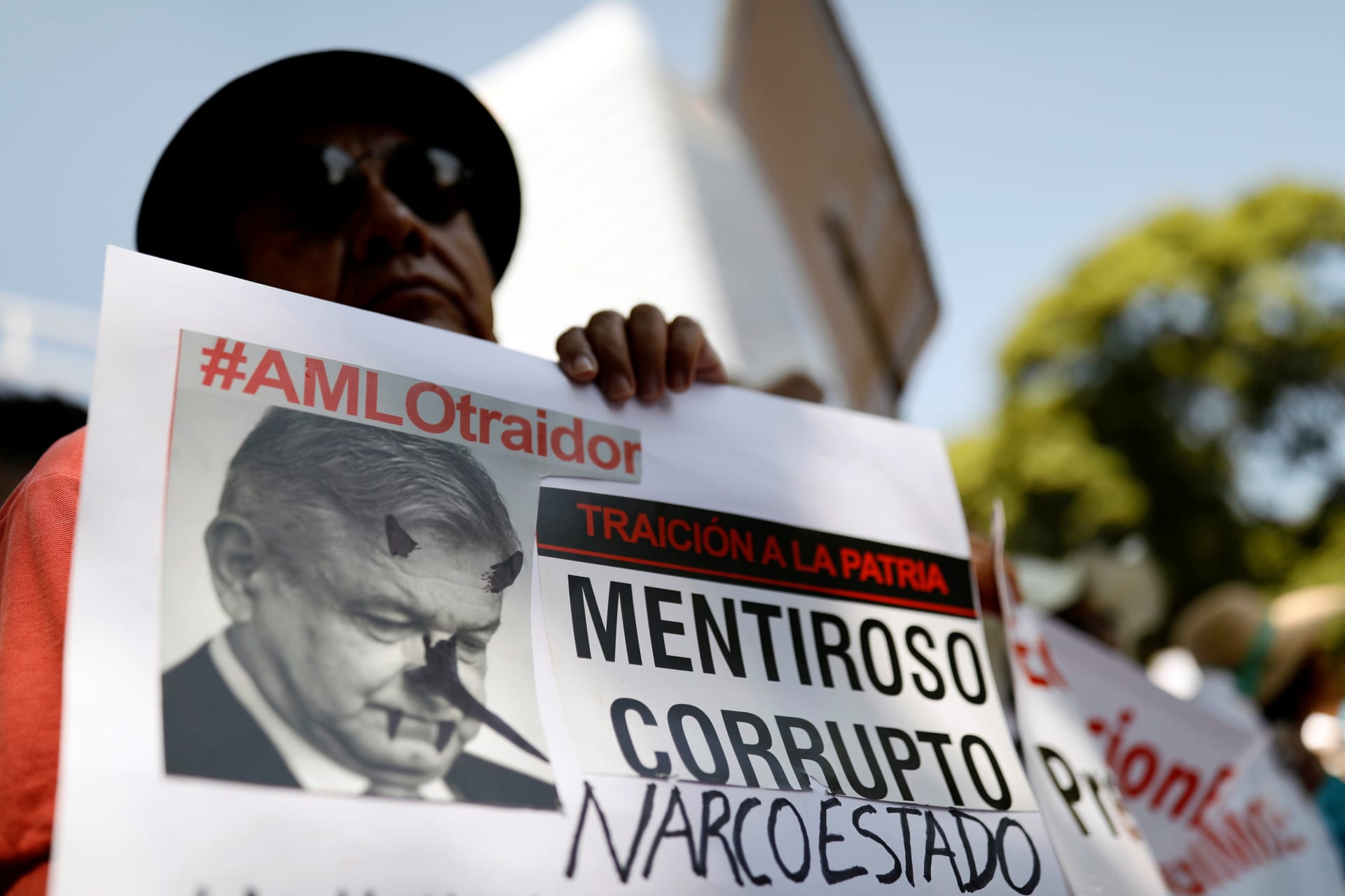 <p>A demonstrator holds a sign during a march against Mexico’s president Andres Manuel Lopez Obrador as he delivers his first state of the union in Mexico City, Mexico, September 1, 2019. The sign reads, “#AMLO traitor. Liar. Corrupt. Narco-state”.</p>
