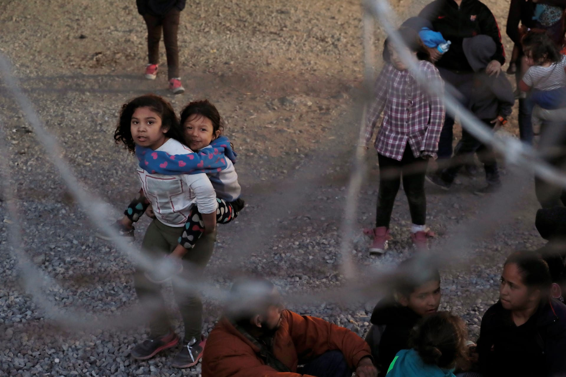 <p>A young girl carries a child inside a U.S. Customs and Border Protection holding area in El Paso, Texas.</p>
