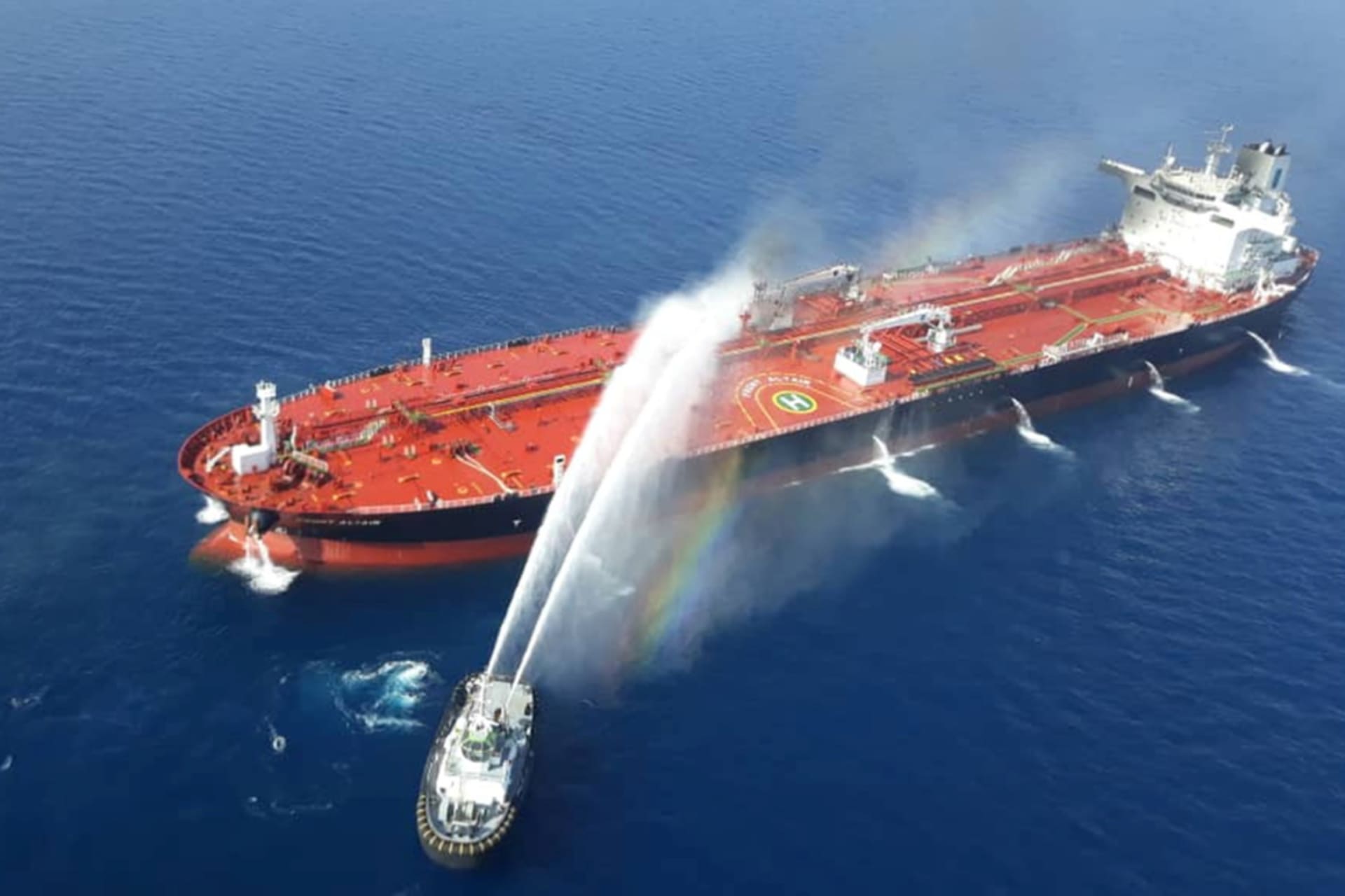 <p>An Iranian navy boat tries to stop the fire of an oil tanker after it was attacked in the Gulf of Oman on June 13, 2019.</p>
