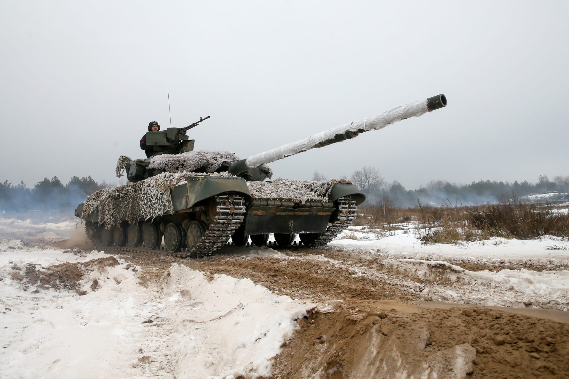 <p>Ukrainian soldiers ride on top of a tank during military exercises in the Chernihiv region of Ukraine on December 3, 2018.</p>
