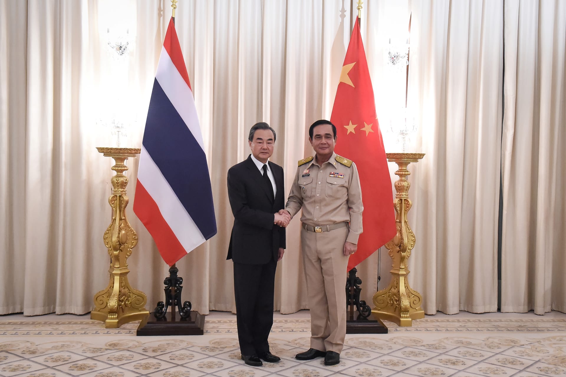 <p>Chinese Foreign Minister Wang Yi (L) shakes hands with Thai Prime Minister Prayuth Chan-ocha (R) at Government House in Bangkok, Thailand on July 24, 2017.</p>
