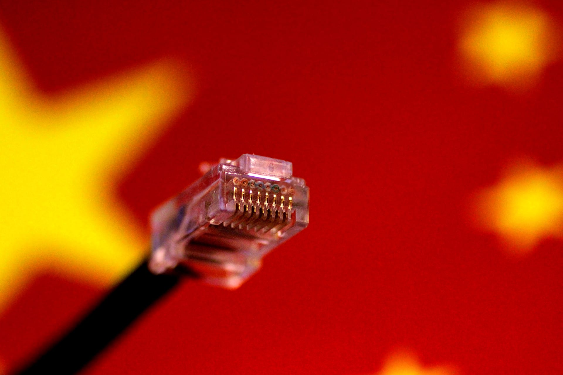 <p>A computer network cable is seen above a Chinese flag</p>
