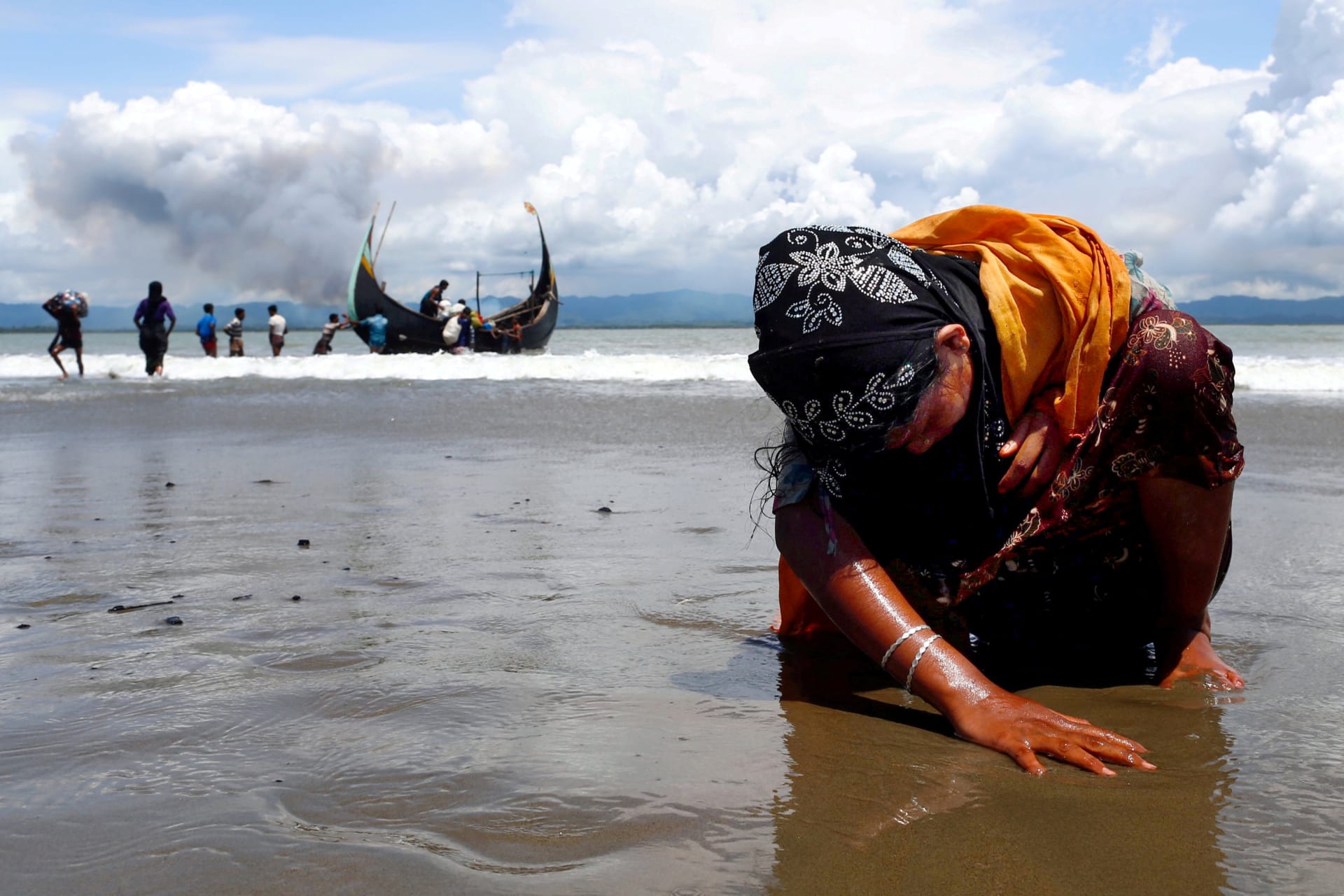 <p>A Rohingya refugee woman touches the shore after crossing the Bangladesh-Myanmar border by boat. September 11, 2017. </p>
