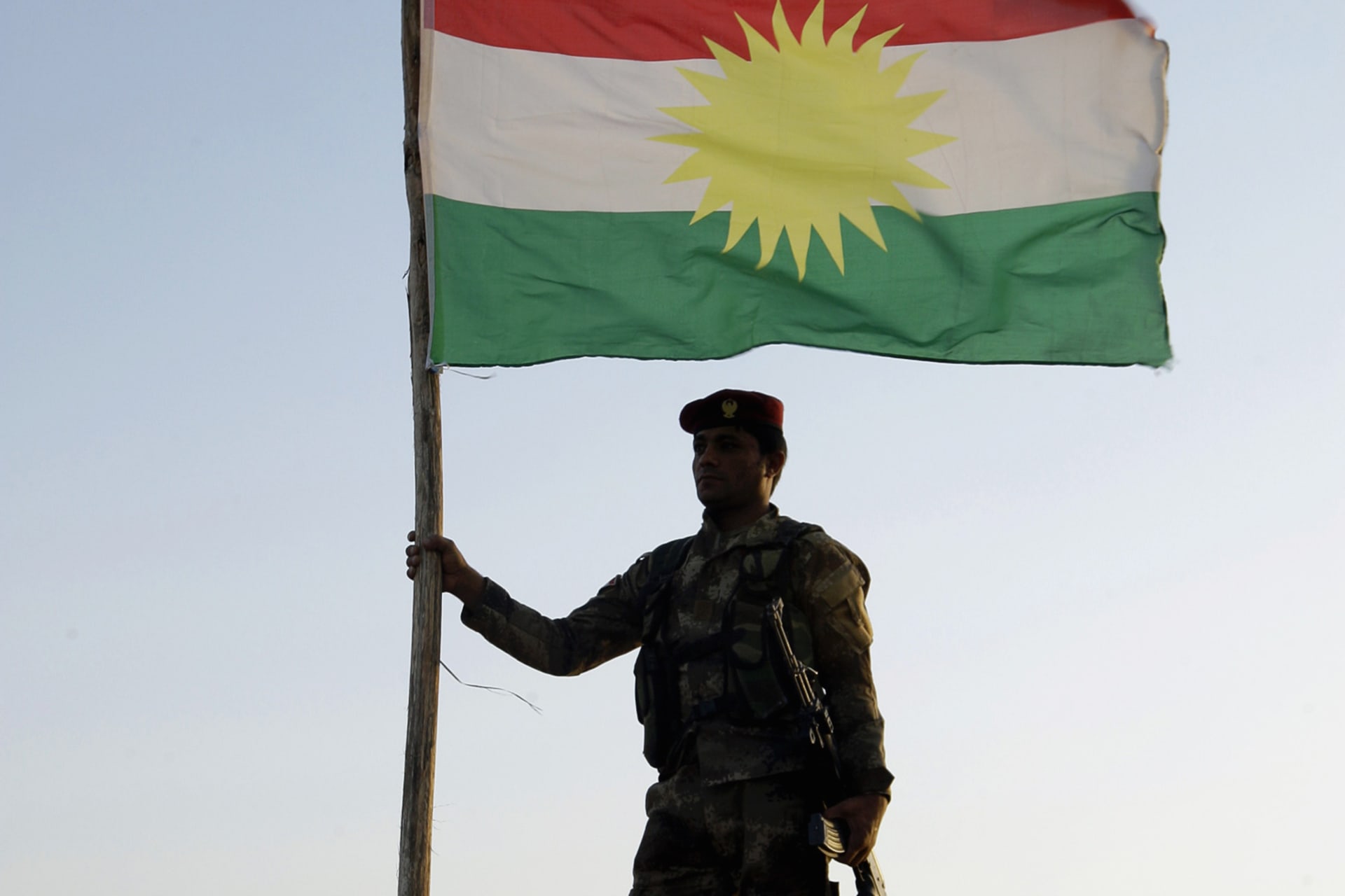 <p>A Kurdish Peshmerga soldier holds a Kurdistan flag during a deployment in the area near the northern Iraqi border with Syria</p>
