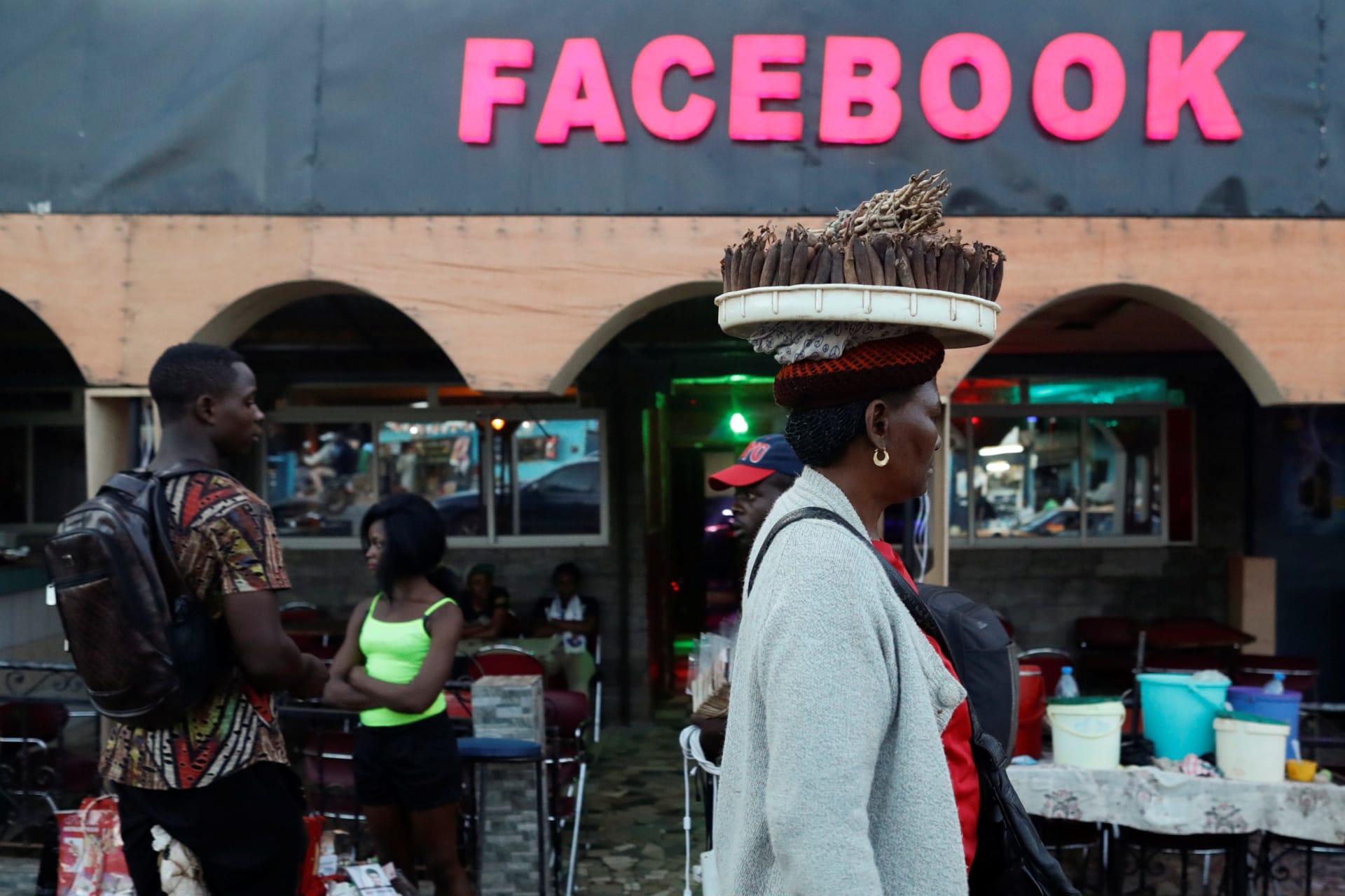 <p>A street vendor walks past a bar called “Facebook” in Yaounde, Cameroon October 2, 2018.</p>
