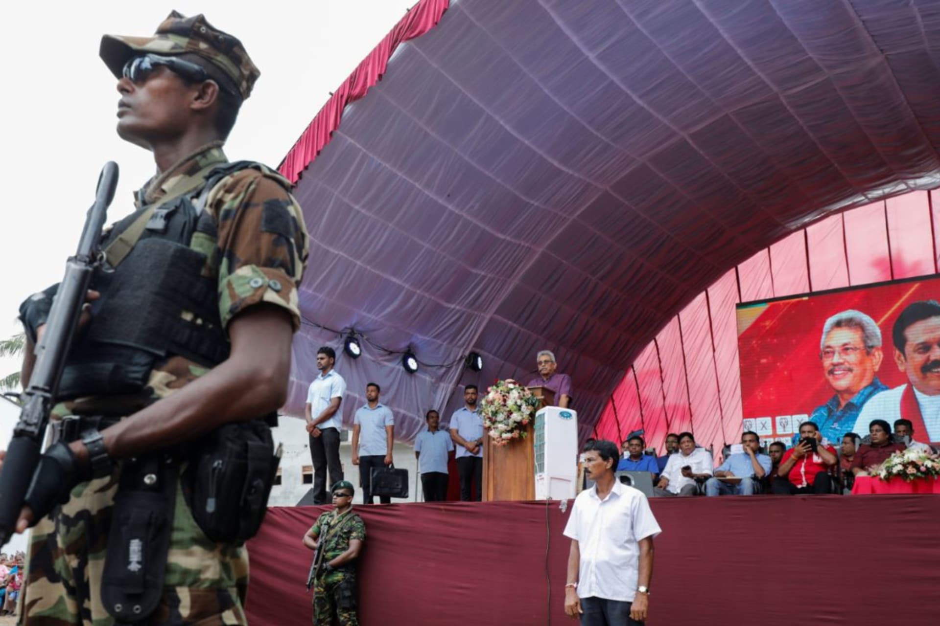<p>A soldier stands guard at a campaign rally for Gotabaya Rajapaksa, at podium, in Bandaragama earlier this month.</p>
