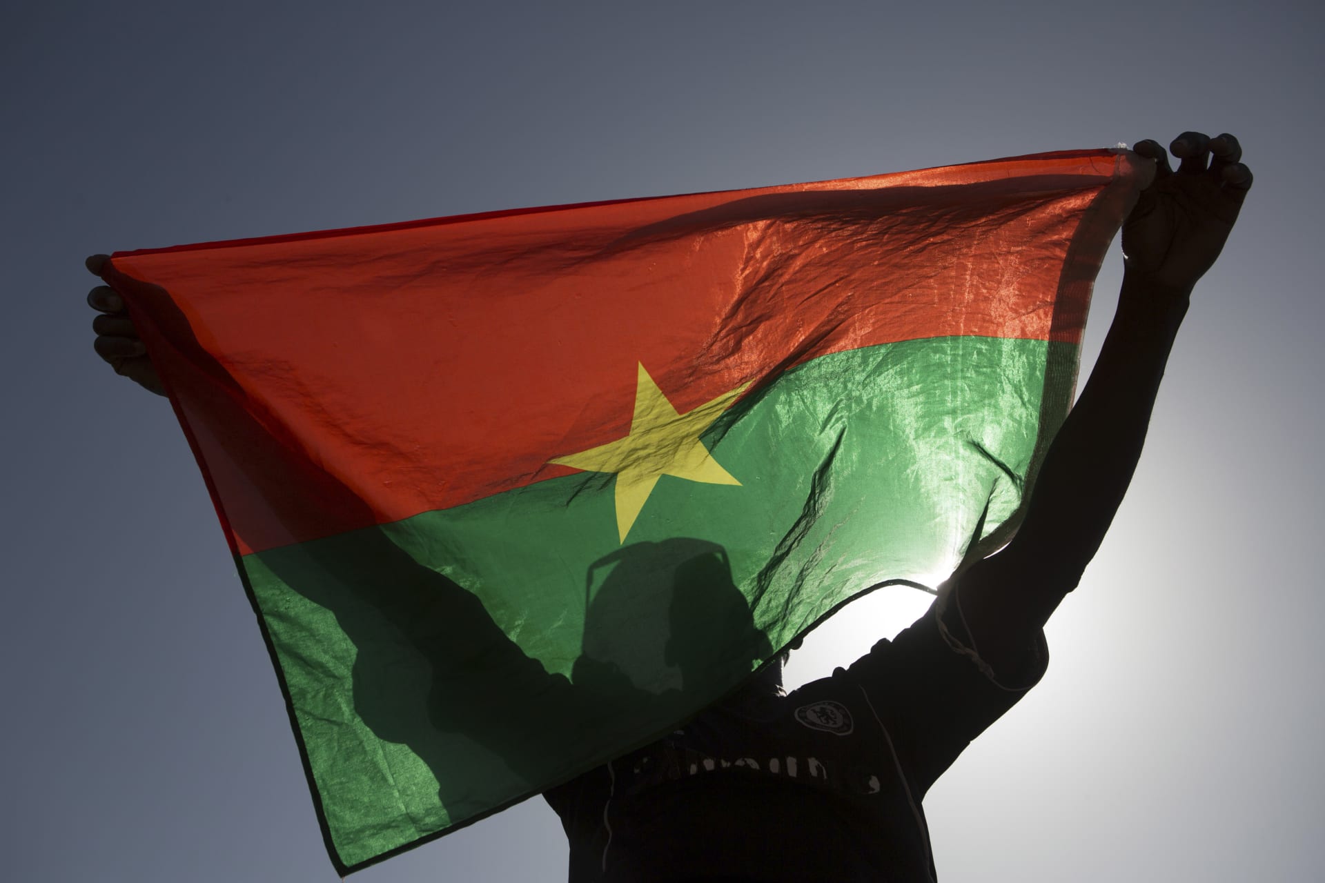 <p>A pro-democracy protester holds up a Burkina Faso flag at Place de la Nation in Ouagadougou, capital of Burkina Faso, November 2, 2014</p>

