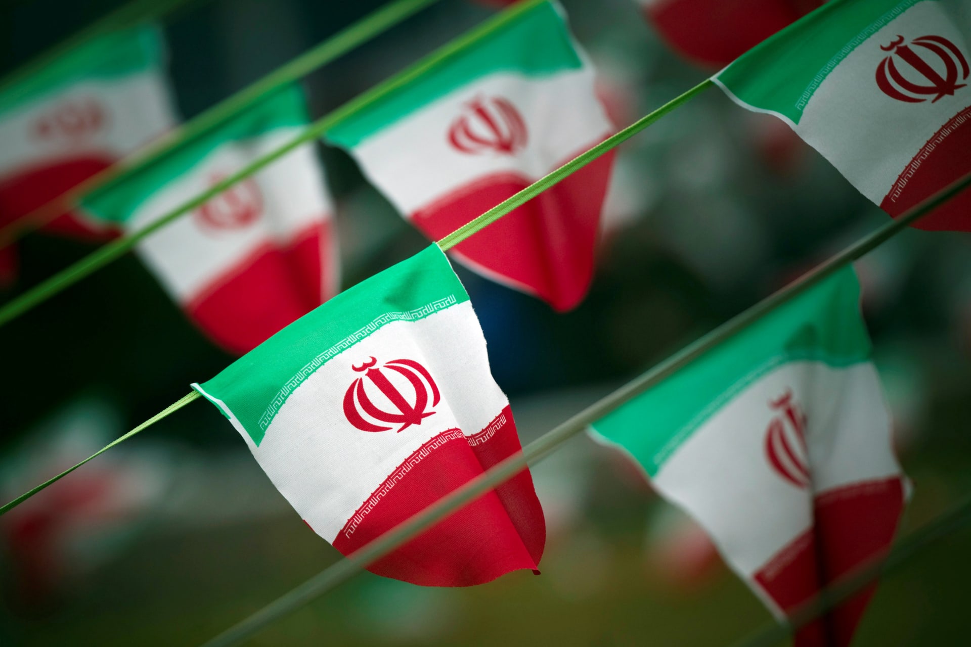 <p>A line of Iranian flags wave in a square in Tehran. </p>
