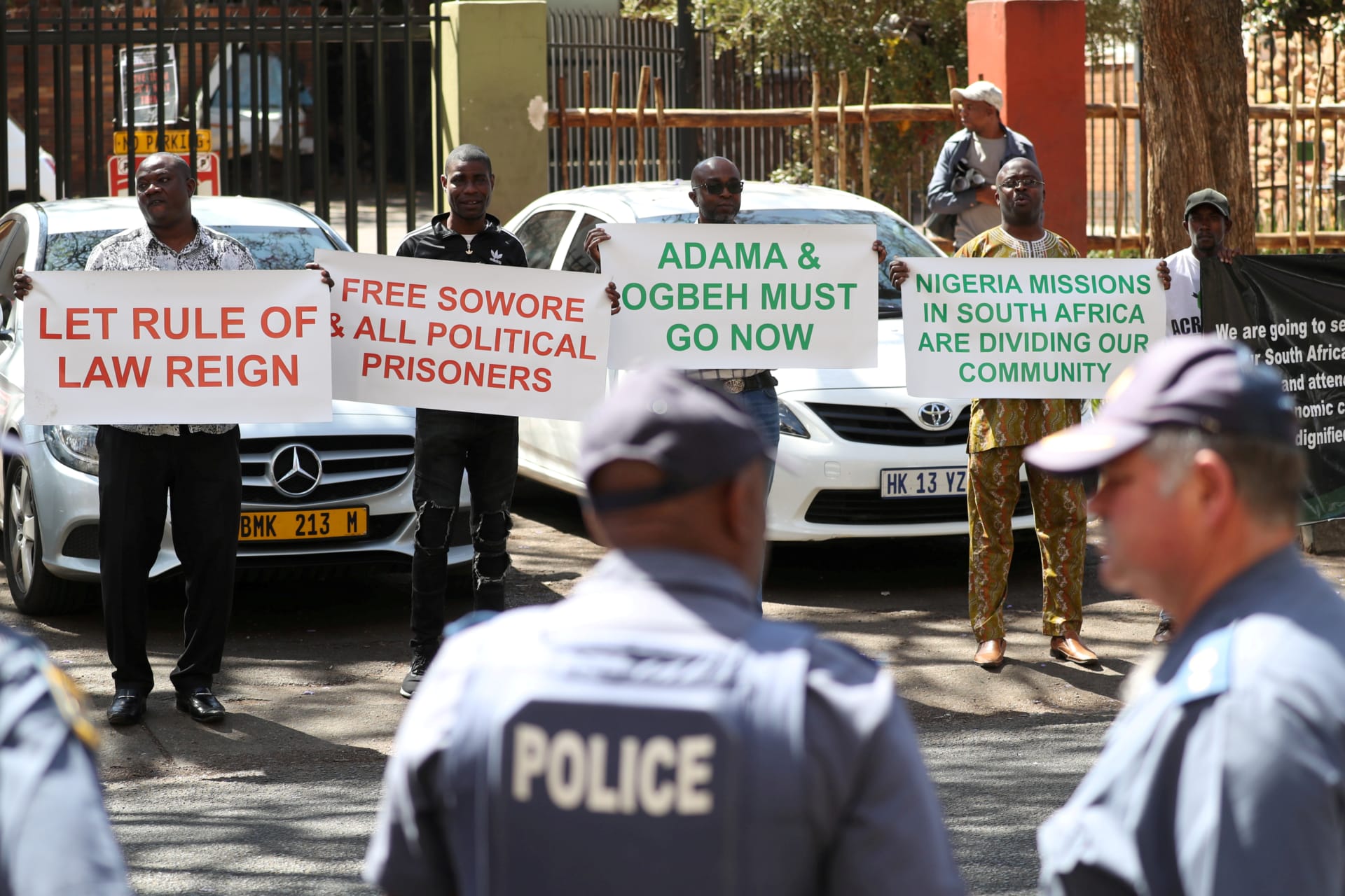 <p>Police officers look on as Nigerians living in South Africa hold placards in protest against President Muhammadu Buhari, as he holds town hall meeting with diaspora living in South Africa following recent xenophobic attacks, in Pretoria, South Africa, Oct</p>
