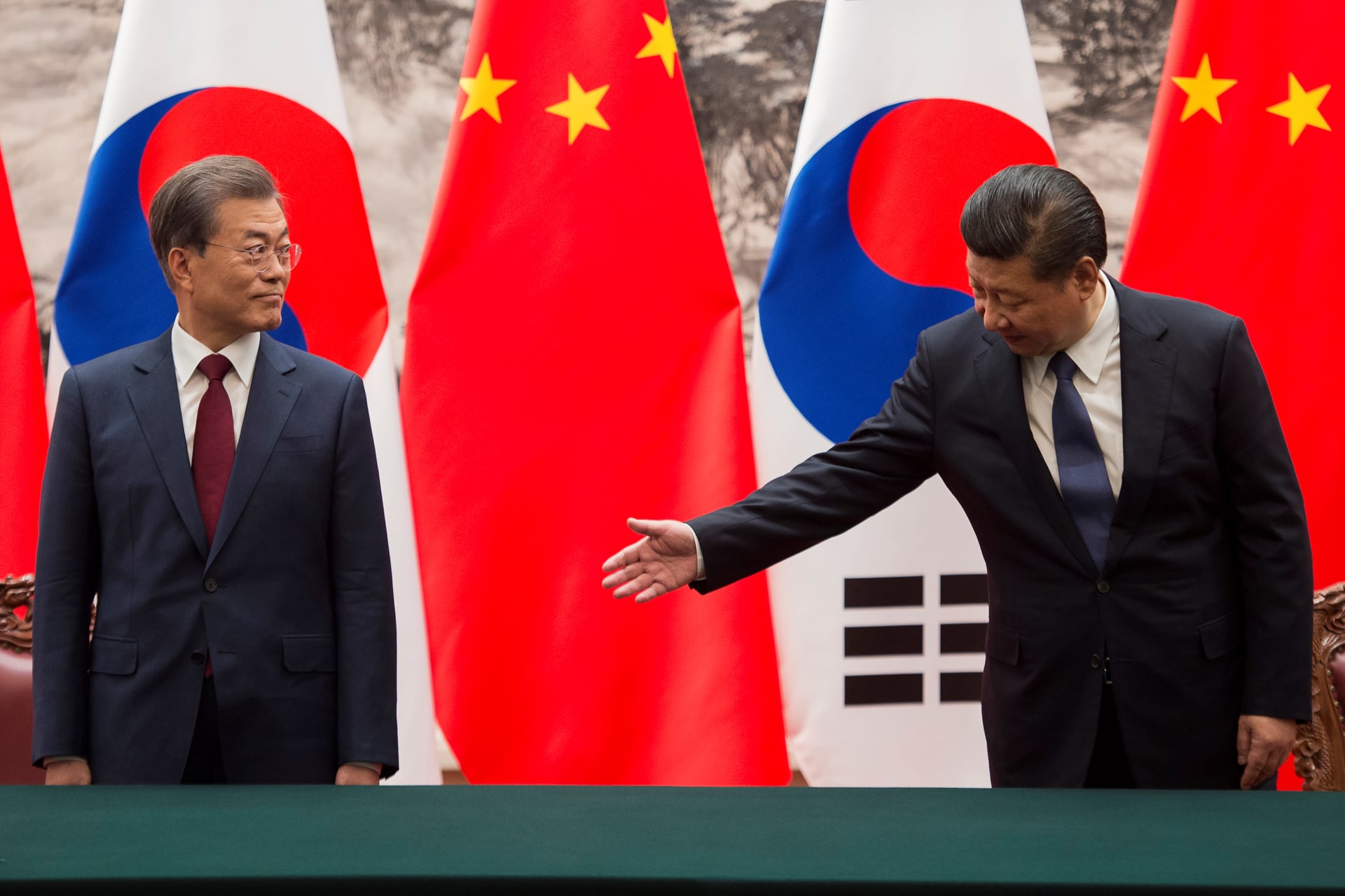 <p>Chinese President Xi Jinping gestures toward South Korean President Moon Jae-in during a signing ceremony at the Great Hall of the People in Beijing, China on December 14, 2017.</p>
