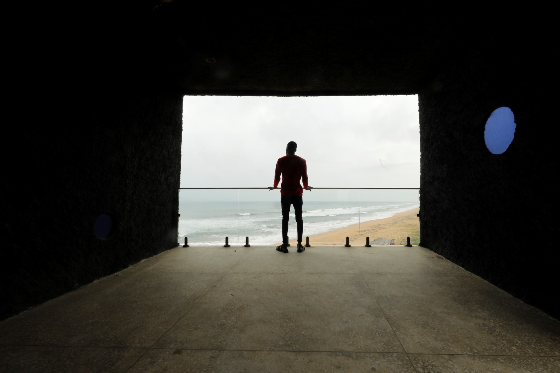 <p>A man looks out at the sea from a building known locally as ‘The Tunnel’ located near the ‘Point of No Return’ where slaves were shipped from the slave port at Badagry, Nigeria, on August 20, 2019.</p>
