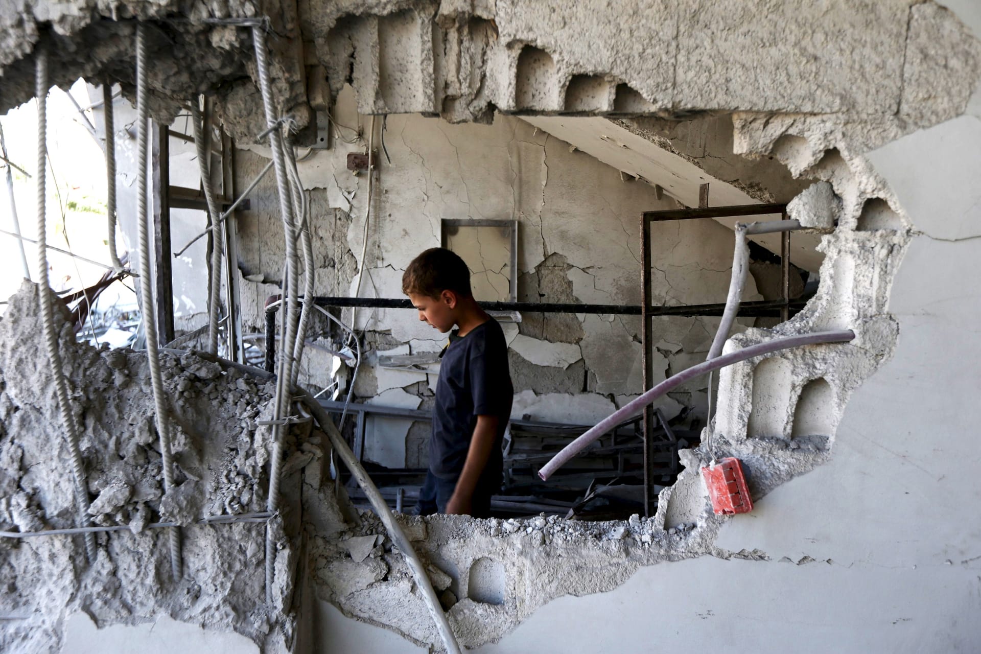 <p>A child inspects a site hit by what activists said was an airstrike by forces loyal to Syria’s President Bashar el-Asaad at Arbin town in Damascus countryside, Syria July 21, 2015.</p>

