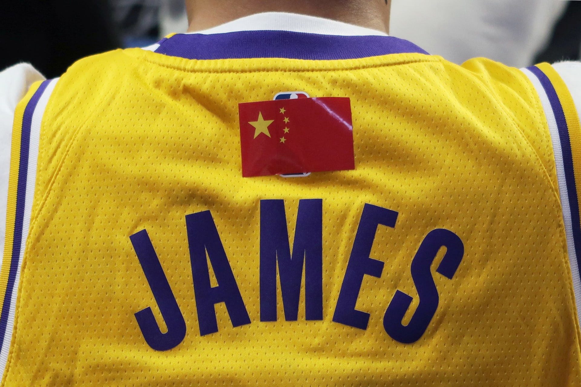 <p> A fan is seen wearing a LeBron James jersey with an NBA logo covered by a Chinese national flag sticker during the game.</p>
