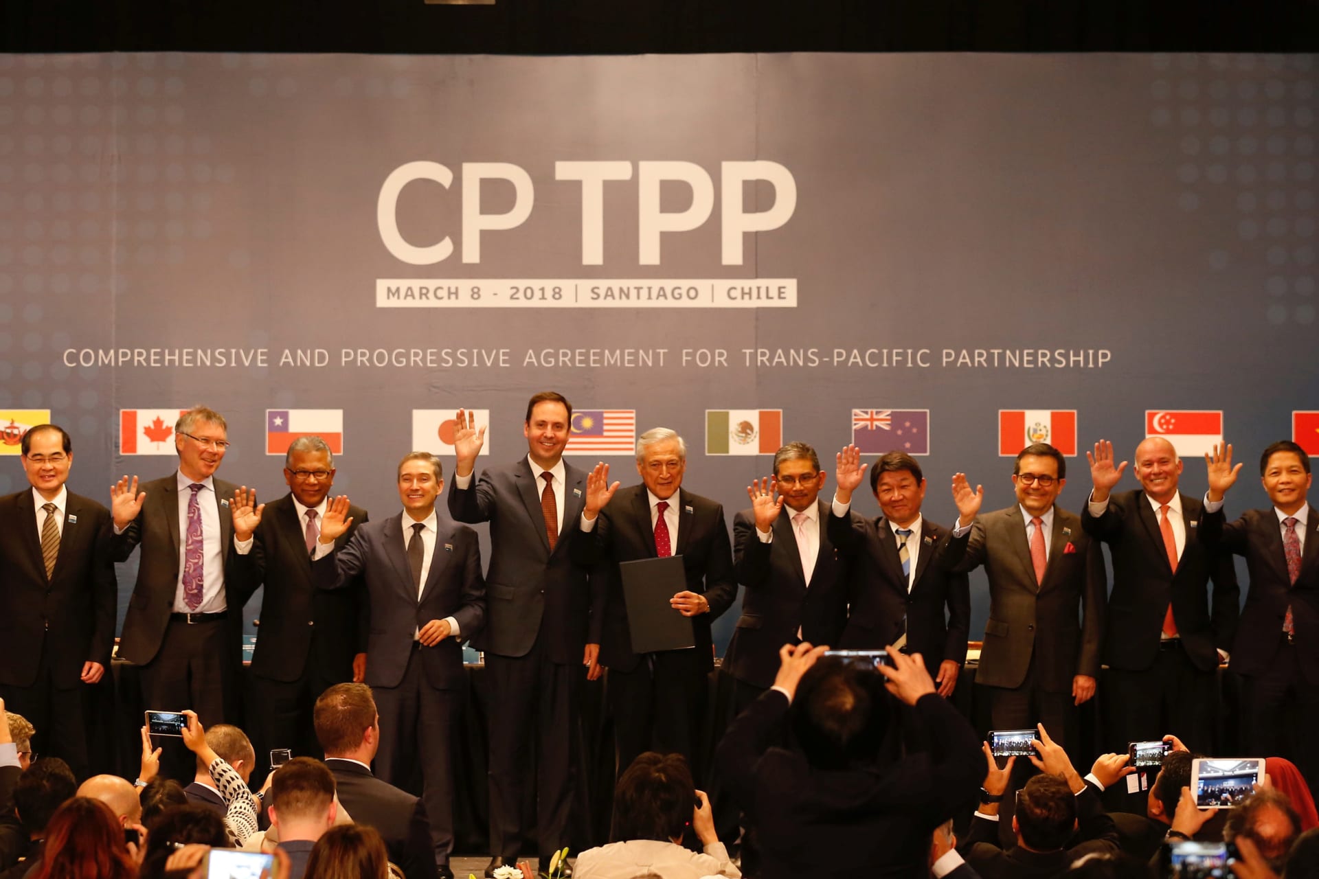 <p>Representatives of members of Trans-Pacific Partnership (TPP) trade deal wave as they pose for an official picture after the signing agreement ceremony in Santiago, Chile March 8, 2018.</p>
