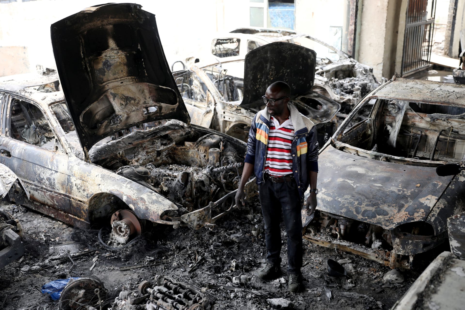 <p>Nigerian entrepreneur Basil Onibo, one of the victims of the latest spate of xenophobic attacks, looks at the burnt out cars at his dealership in Johannesburg, South Africa, on September 5, 2019.</p>
