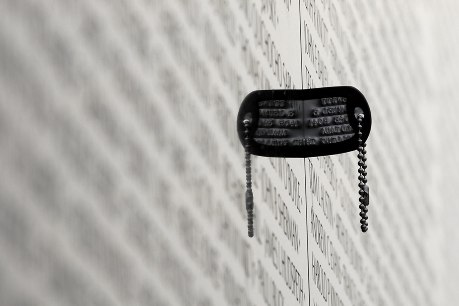 <p>A dog tag is wedged between panels of the Vietnam Veterans Memorial in Washington, DC.</p>
