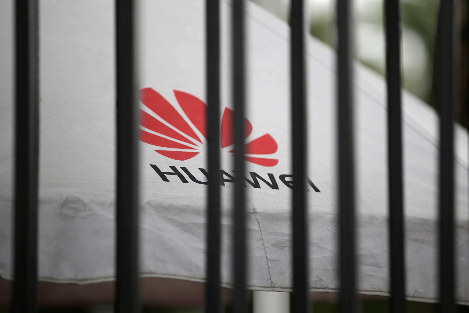 <p>A Huawei logo is seen outside the fence at its headquarters in Shenzhen.</p>