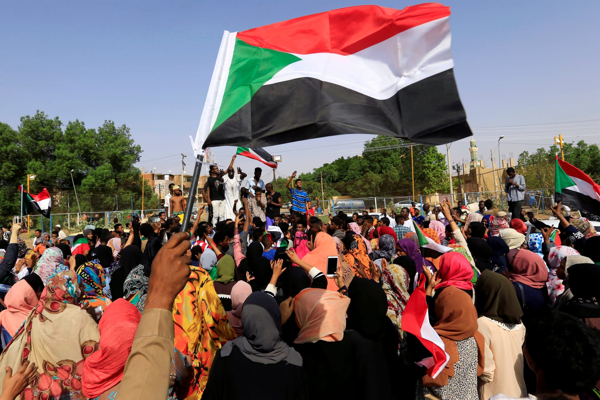 <p>Sudanese demonstrators wave their national flag on the streets of Khartoum in celebration after the country’s ruling military council and a coalition of opposition groups reached an agreement to share power during a transition period, July 5, 2019</p>
