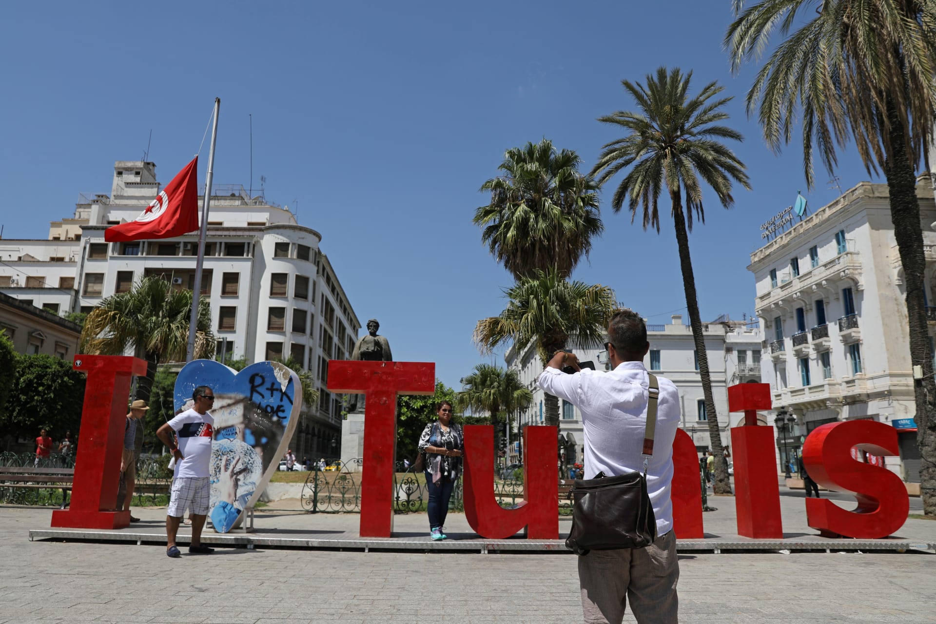 <p>People pose for a photo with “I love Tunis” sign as a Tunisian flag flies at half-mast in honor of late Tunisian President Beji Caid Essebsi, in Tunis, Tunisia July 28, 2019.</p>
