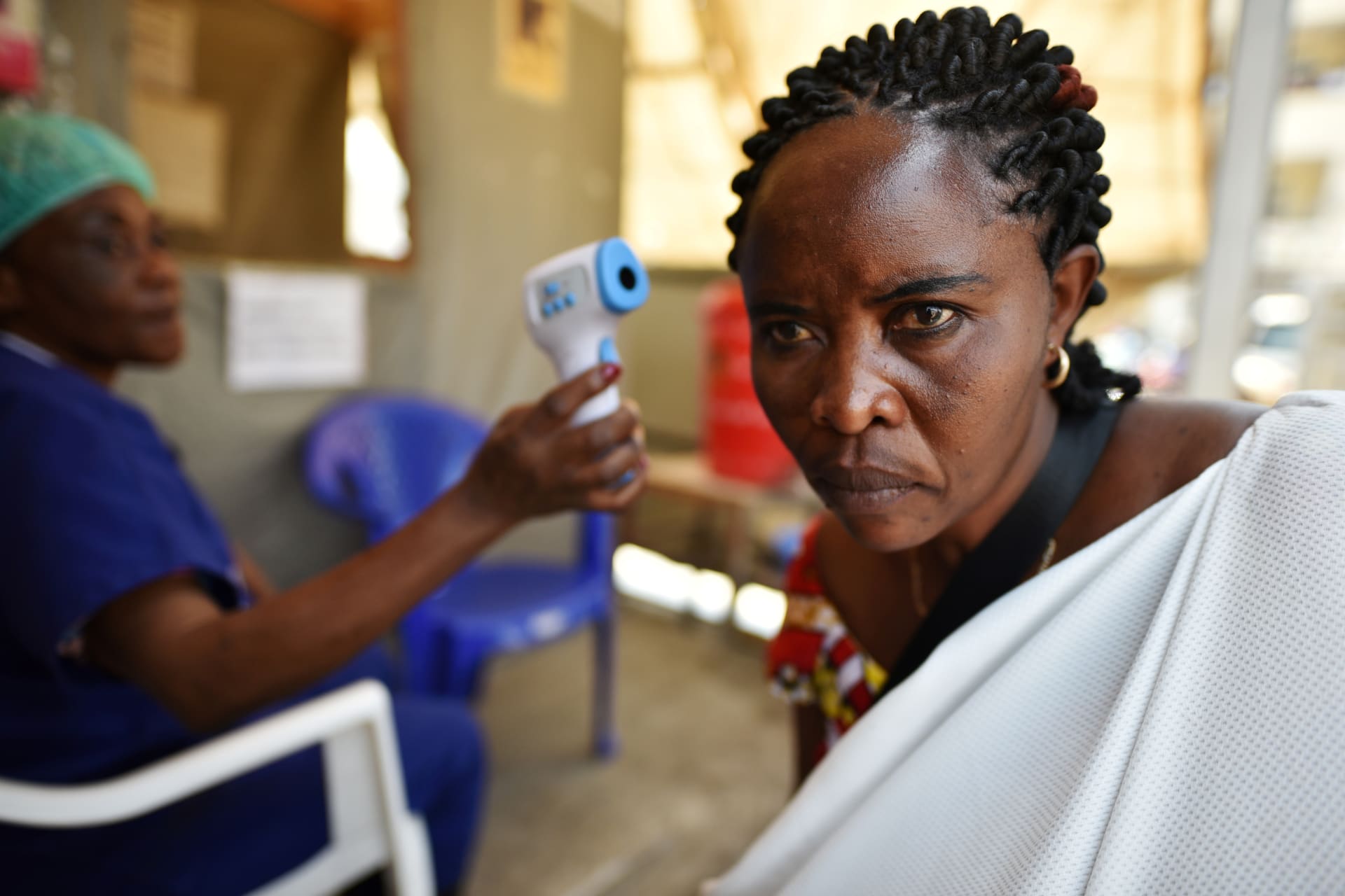 <p>A health worker checks the temperature of a woman as part of the Ebola screening upon entering the General Hospital in Goma, Democratic Republic of Congo on July 15, 2019. </p>

