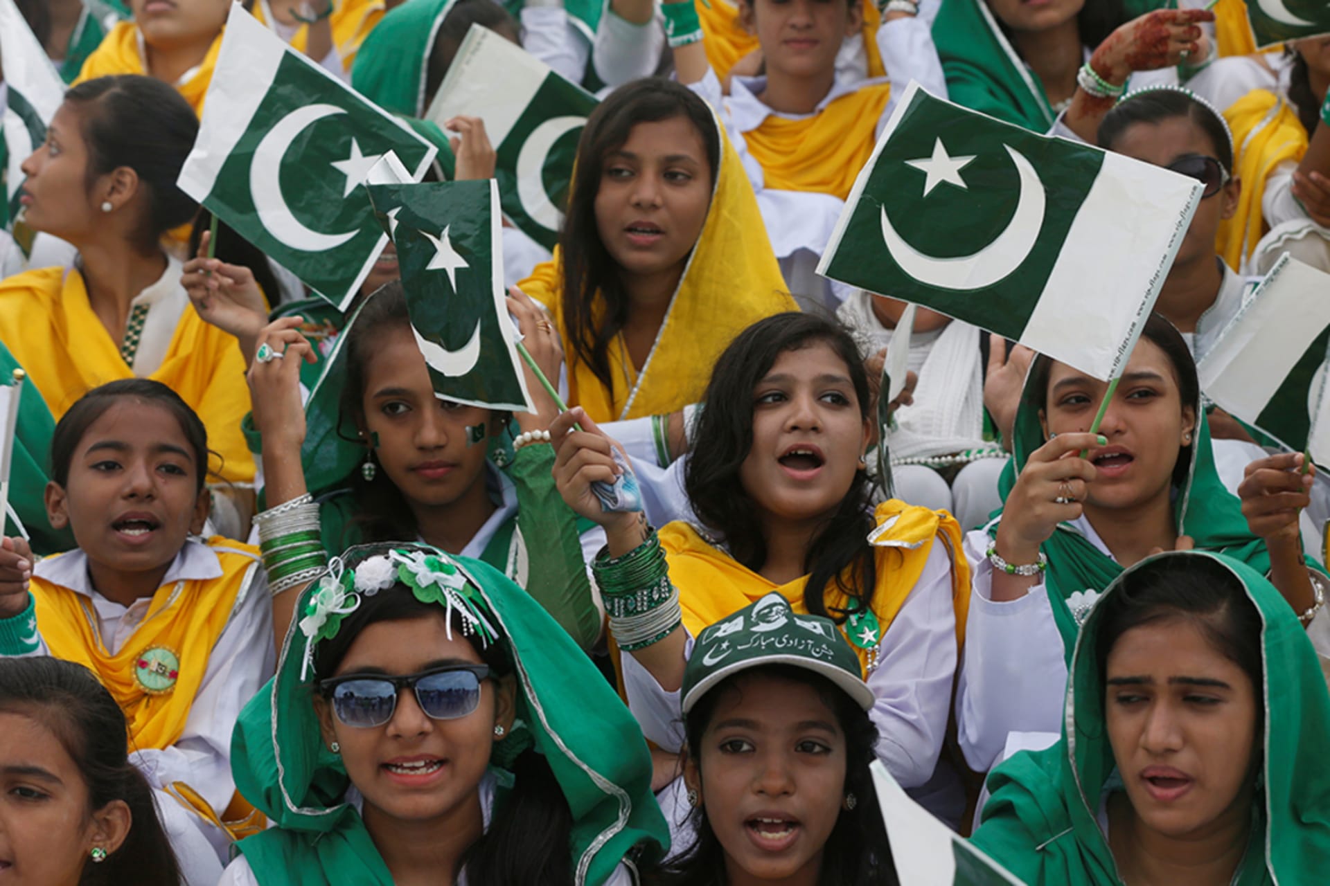 <p>Attendees wave Pakistan’s national flag at a ceremony to celebrate the country’s seventieth independence day in Karachi.</p>
