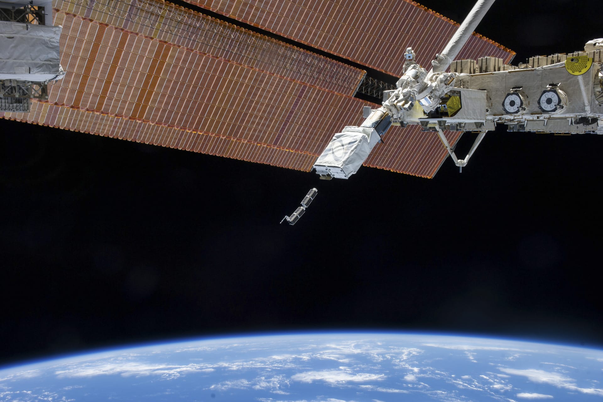 <p>The Small Satellite Orbital Deployer, in the grasp of the Kibo laboratory robotic arm, deploys a set of NanoRacks CubeSats.</p>
